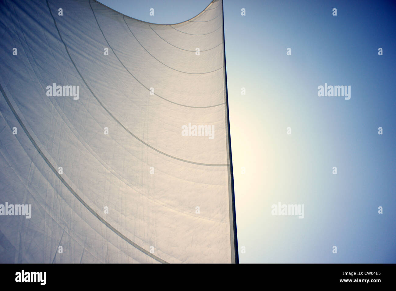 Detail of  flared sails of a sailing yacht, making its way under the sun, across the Ionian Sea. Stock Photo