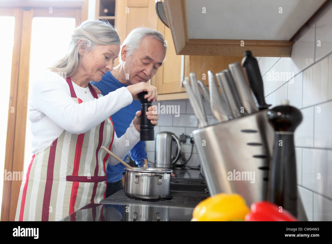 Older couple cooking together in kitchen Stock Photo