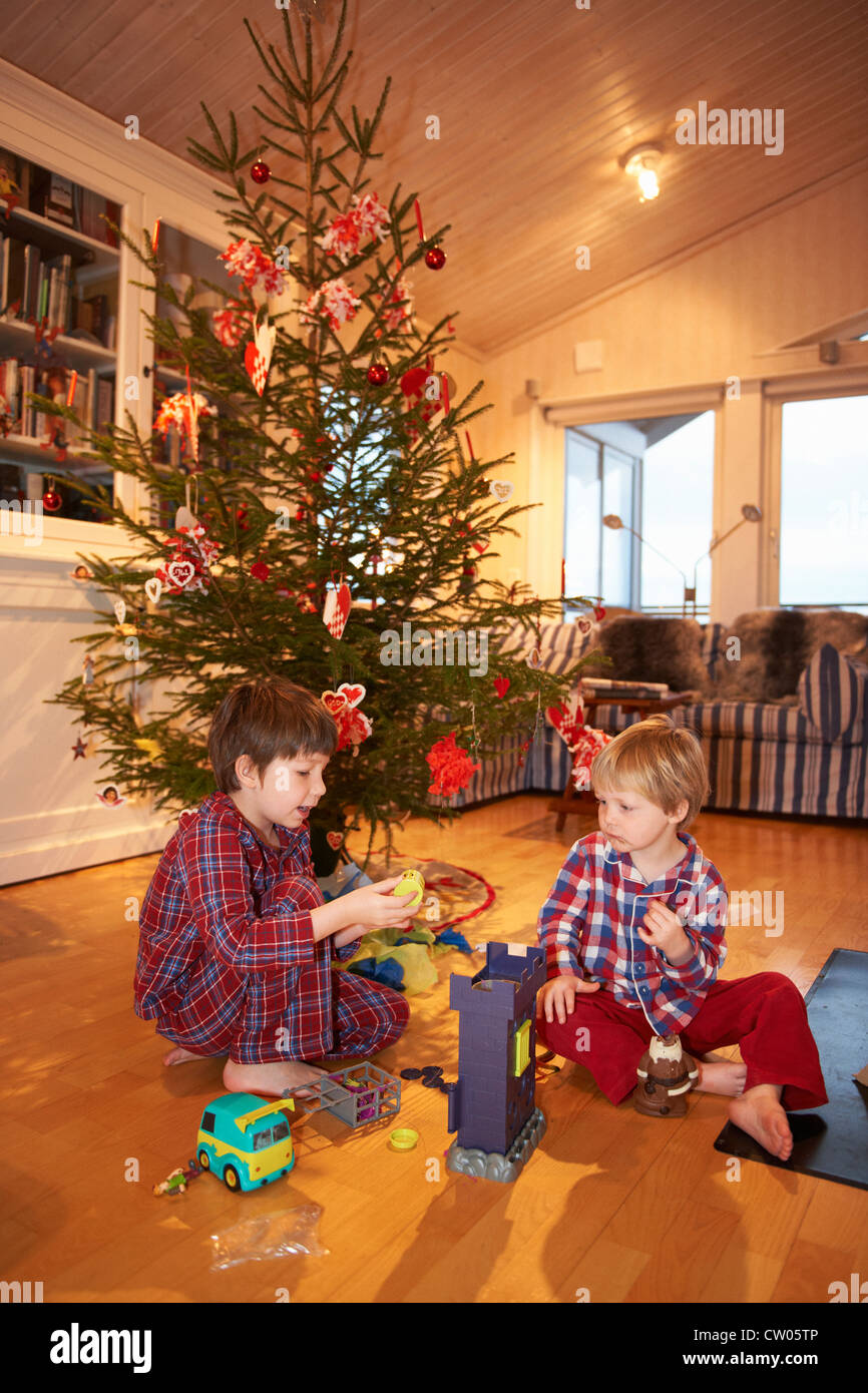 Boys playing under Christmas tree Stock Photo - Alamy