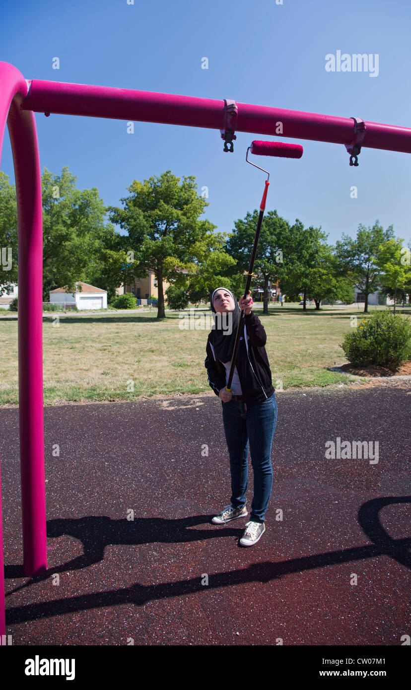 Volunteers paint playground equipment in Detroit's Romanowski Park