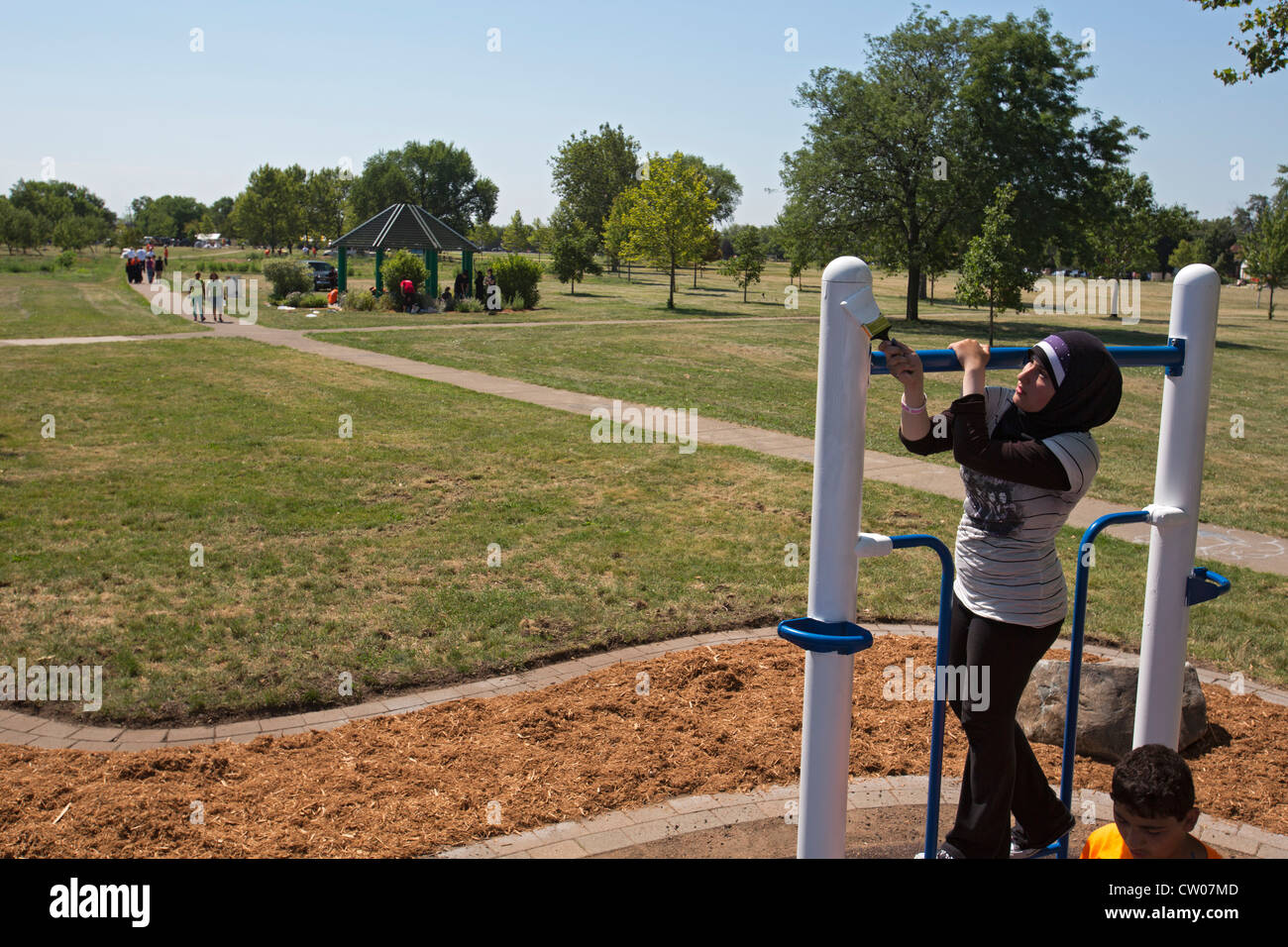 Volunteers paint playground equipment in Detroit's Romanowski Park