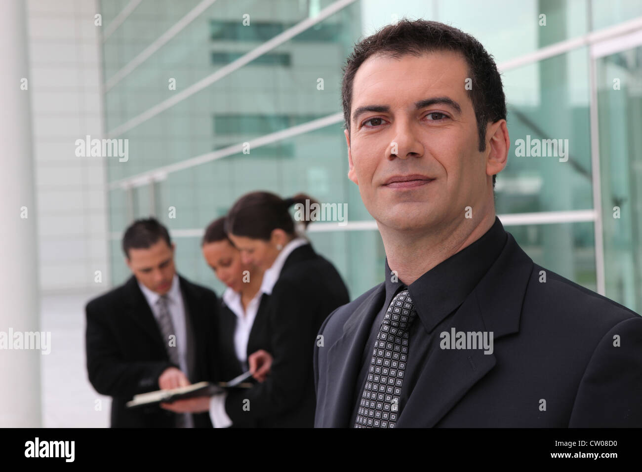 Confident businessman and business team outdoors Stock Photo - Alamy