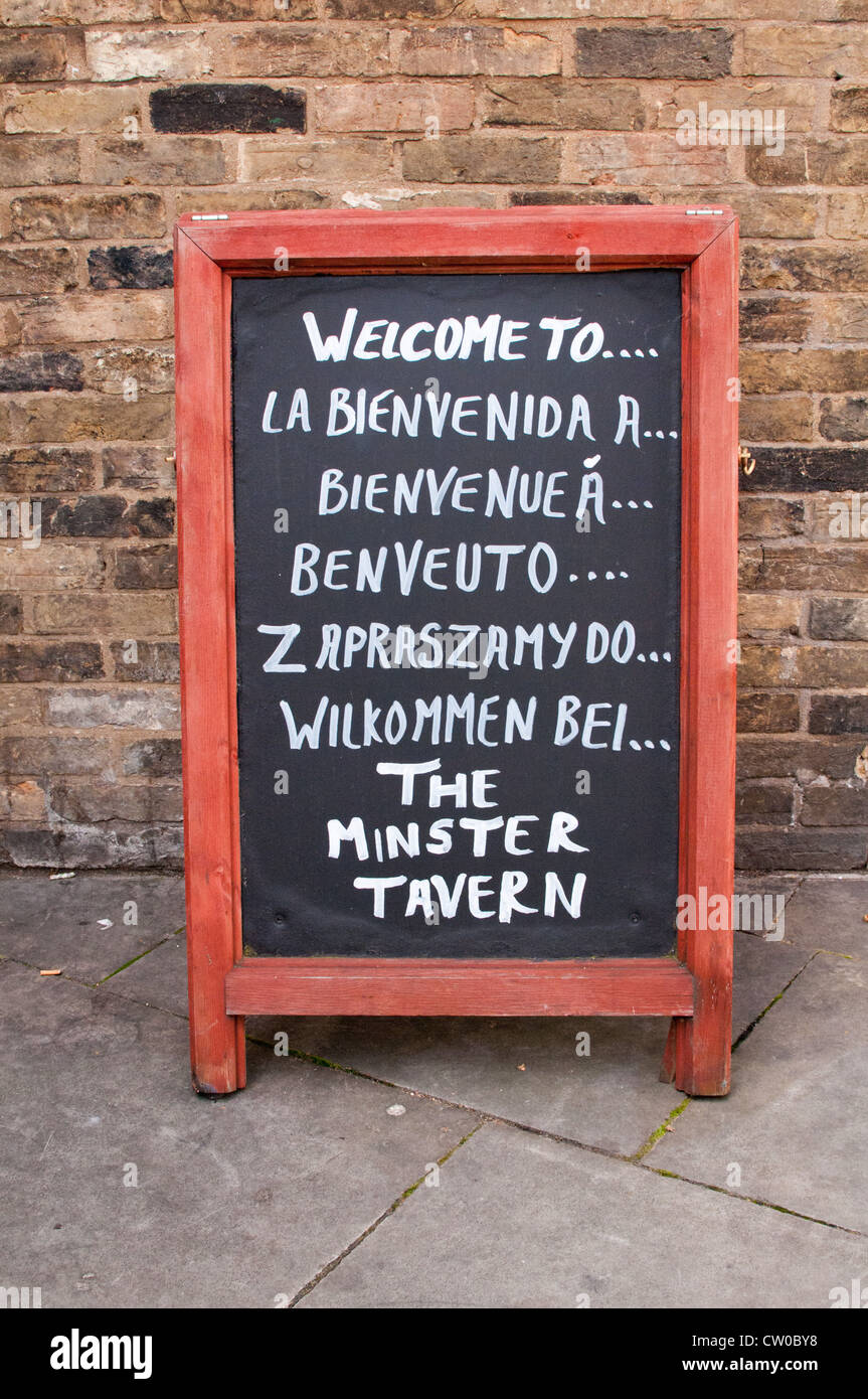 Handwritten multi-lingual welcome sign at an English tavern, UK. Stock Photo
