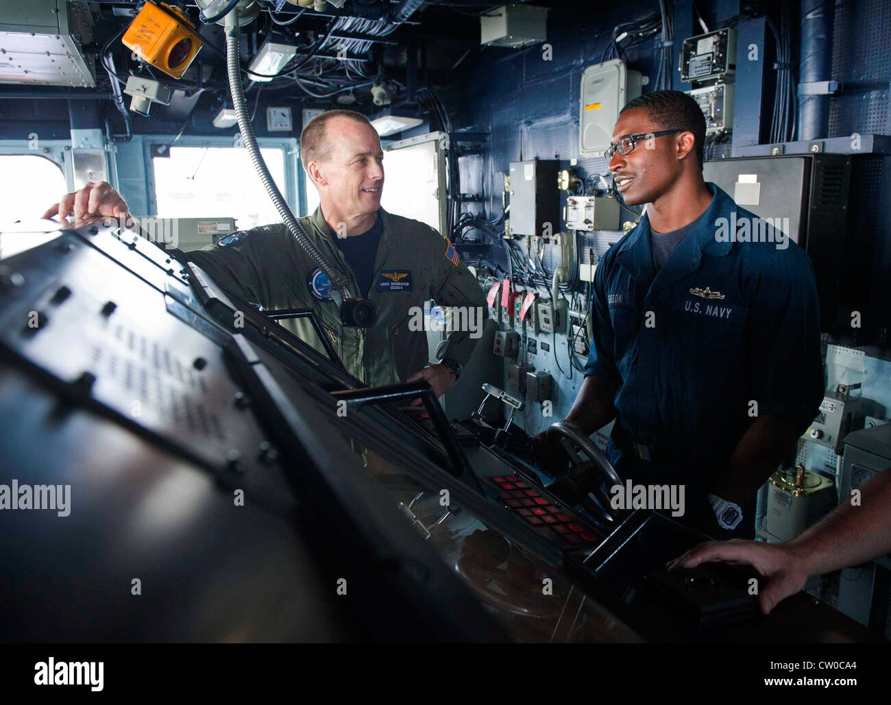 Rear Adm. Mike Shoemaker, commander of Carrier Strike Group (CSG) 9, speaks with Seaman Mark Gibson on the bridge of the Ticonderoga-class guided-missile cruiser USS Cape St. George (CG 71). Cape St. George is deployed as part of CSG 9, which is operating in the U.S. 6th Fleet area of responsibility in support of maritime security operations and theater security cooperation efforts. Stock Photo