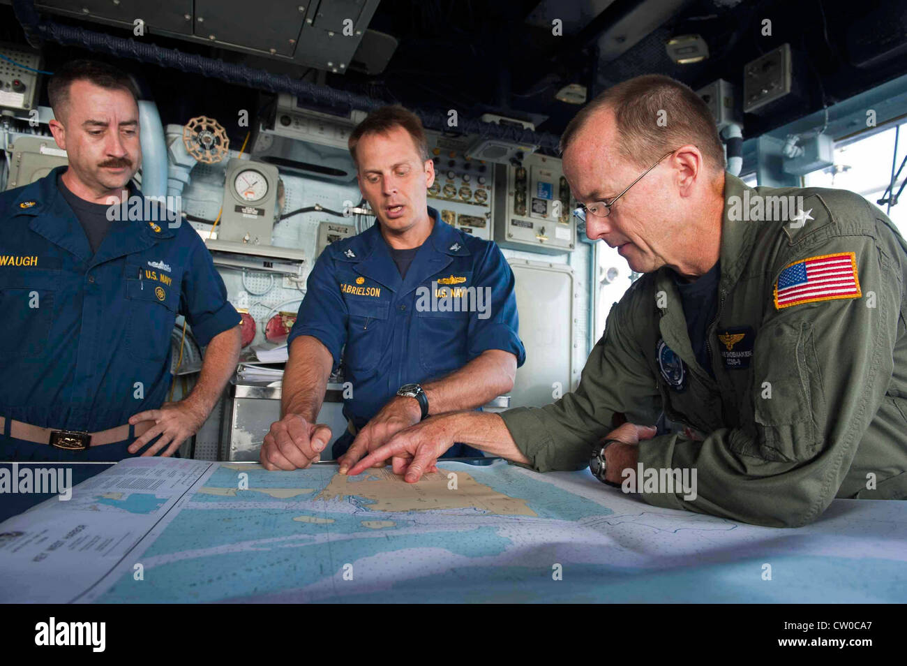 Rear Adm. Mike Shoemaker, commander of Carrier Strike Group (CSG) 9, and Capt. Don Gabrielson, commanding officer of the Ticonderoga-class guided-missile cruiser USS Cape St. George (CG 71), view a nautical chart on the ship's bridge. Cape St. George is deployed as part of Carrier Strike Group (CSG) 9, which is operating in the U.S. 6th Fleet area of responsibility in support of maritime security operations and theater security cooperation efforts. Stock Photo