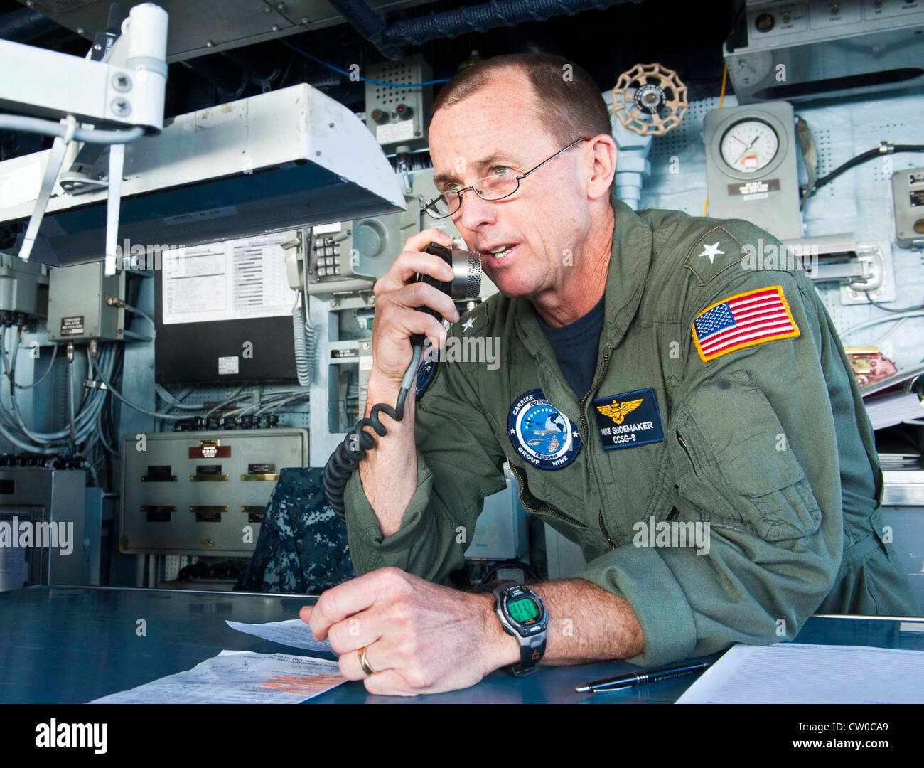 Rear Adm. Mike Shoemaker, commander of Carrier Strike Group (CSG) 9, addresses the crew of the Ticonderoga-class guided-missile cruiser USS Cape St. George (CG 71) from the ship's bridge. Cape St. George is deployed as part of CSG 9, which is operating in the U.S. 6th Fleet area of responsibility in support of maritime security operations and theater security cooperation efforts. Stock Photo