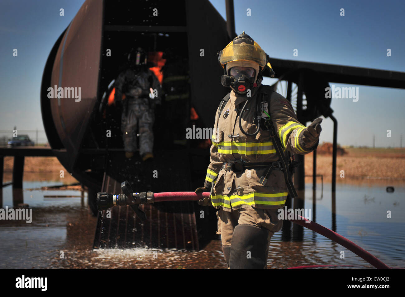 A member of the Clovis, N.M., Fire Department gestures for another member to follow her into the