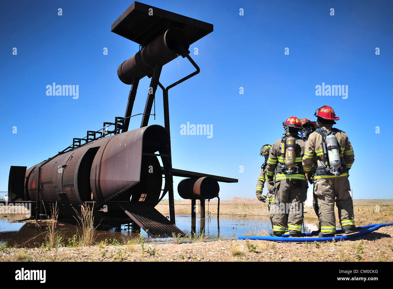 Members of the Clovis, N.M., Fire Department prepare to enter the burn pit to extinguish a fire