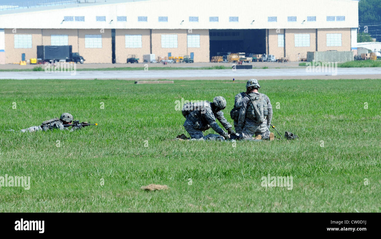 A Fort Campbell Soldier with 4th Brigade Combat Team (left) provides security as members of his team conduct first aid on a mock casualty during a rehearsal at Fort Campbell Army Airfield Tuesday. This demonstration was a rehearsal for the air assault that will occur Saturday as part of the Fort Campbell air show, which begins at 10 a.m. Stock Photo