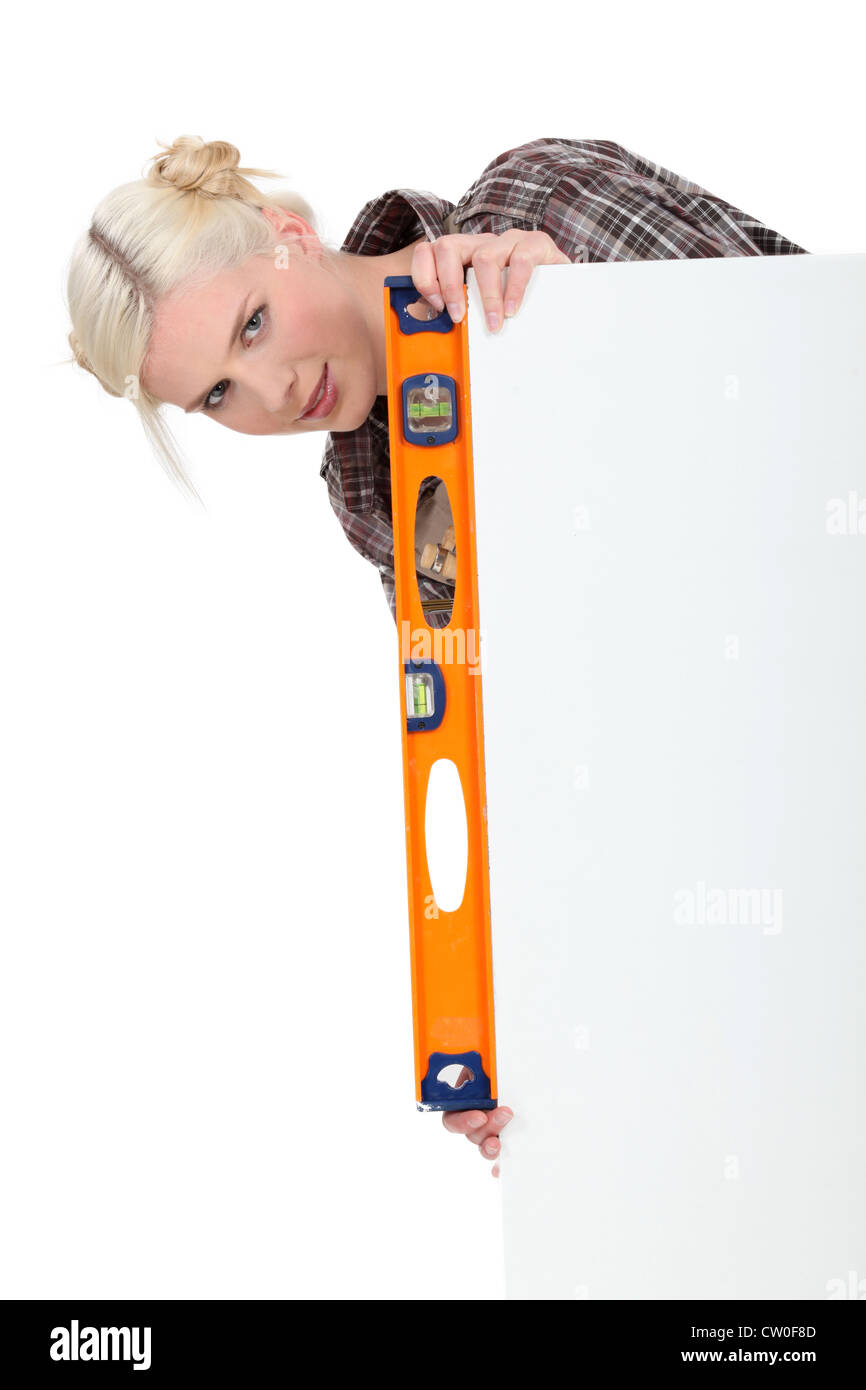Woman with a spirit level and a board left blank for message or image Stock Photo