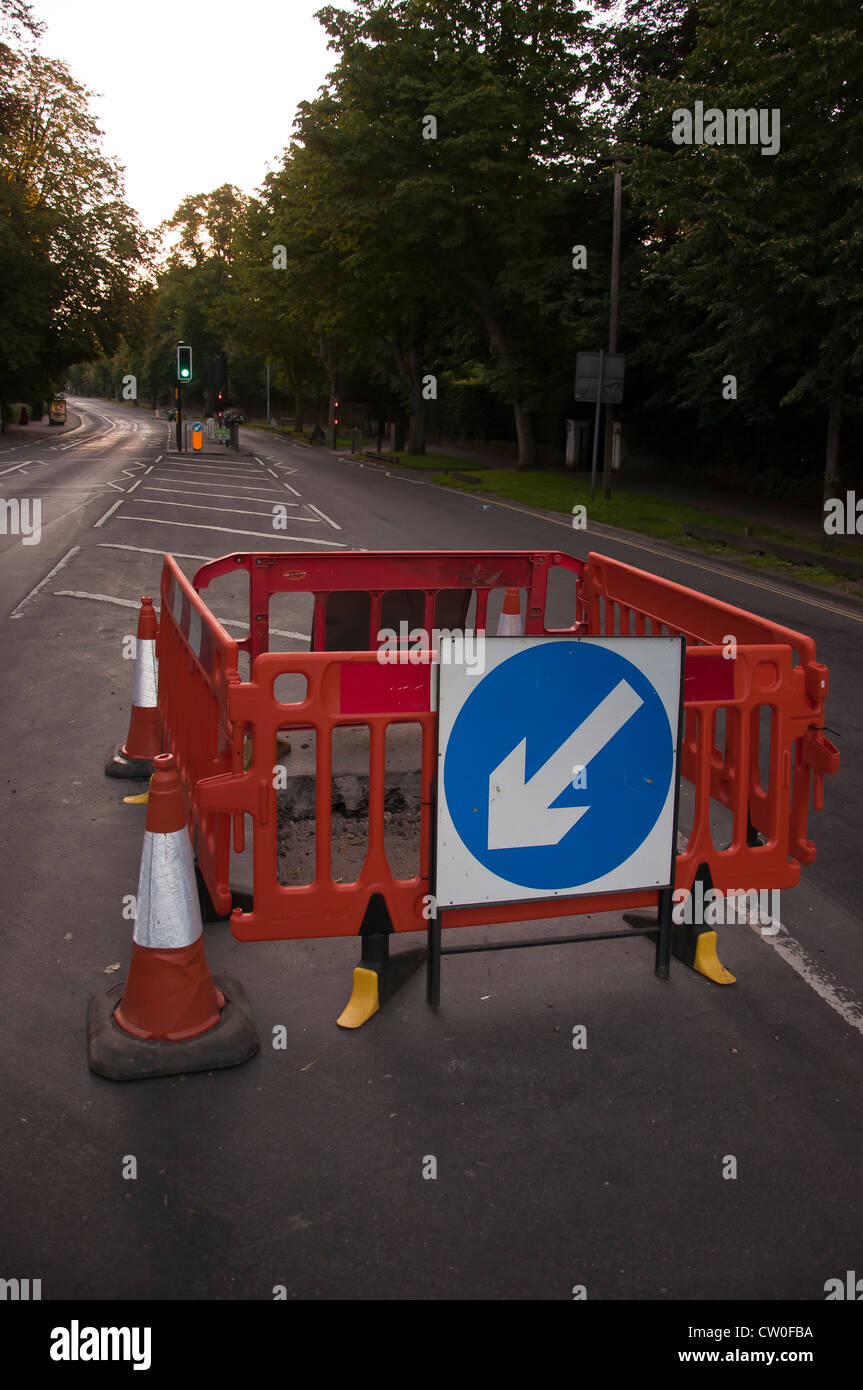 Hole in road roadworks with  Keep left sign Stock Photo