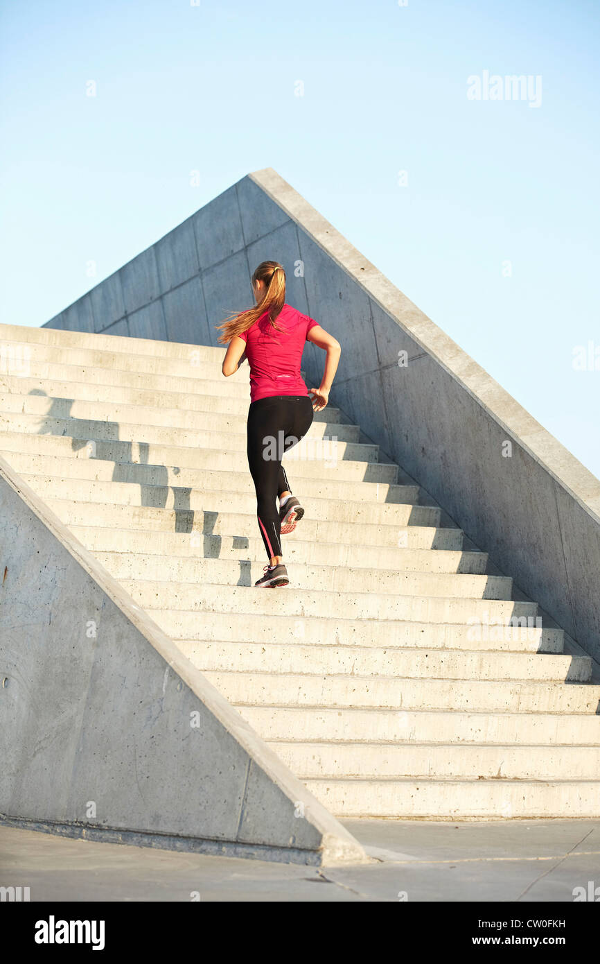 Woman running on staircase Stock Photo
