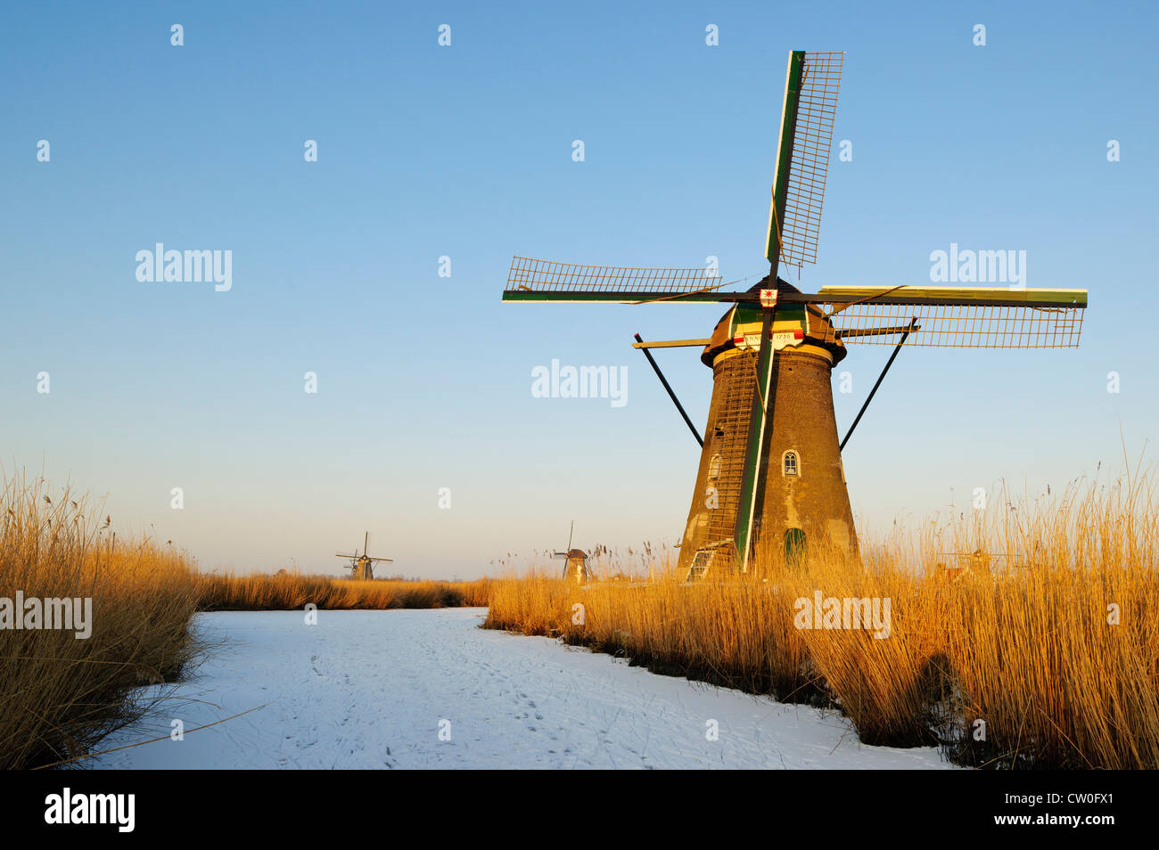 Windmill by river in rural landscape Stock Photo