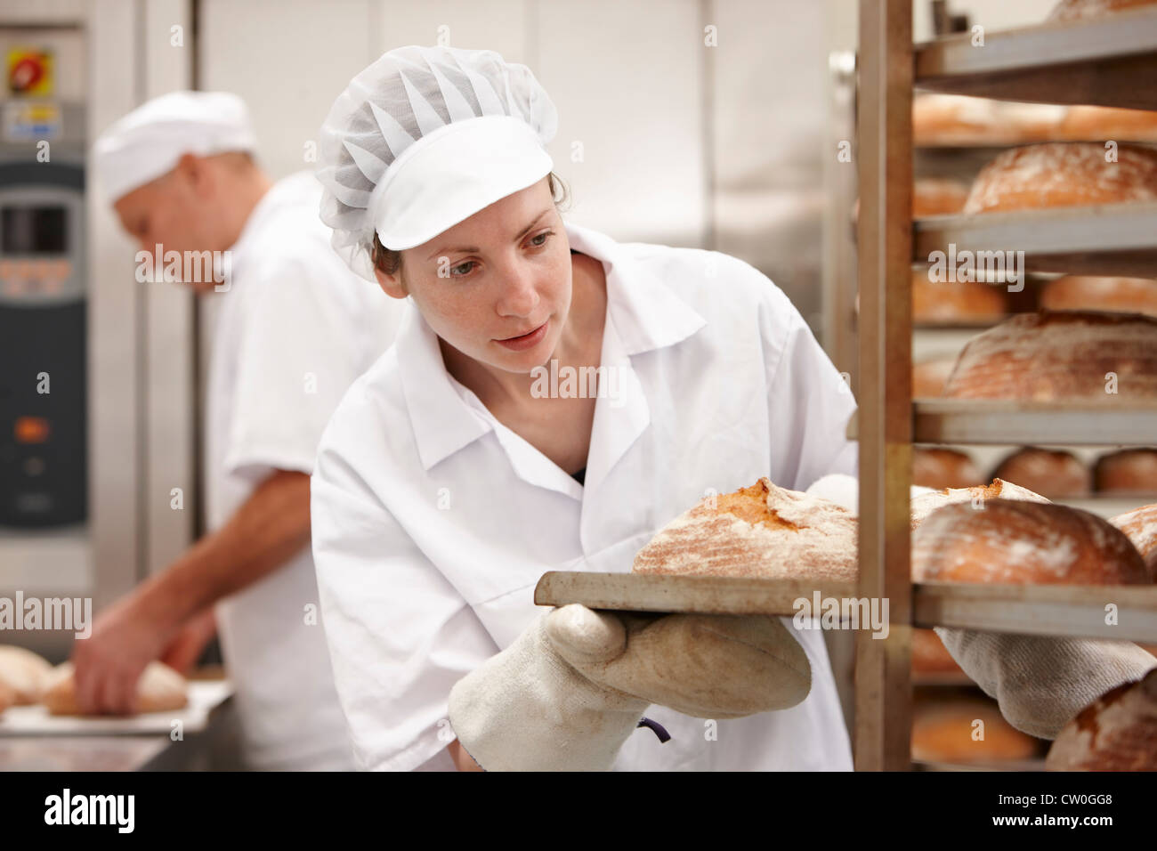 Chef carrying tray of bread in kitchen Stock Photo