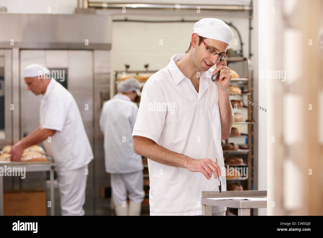Chef talking on phone in kitchen Stock Photo