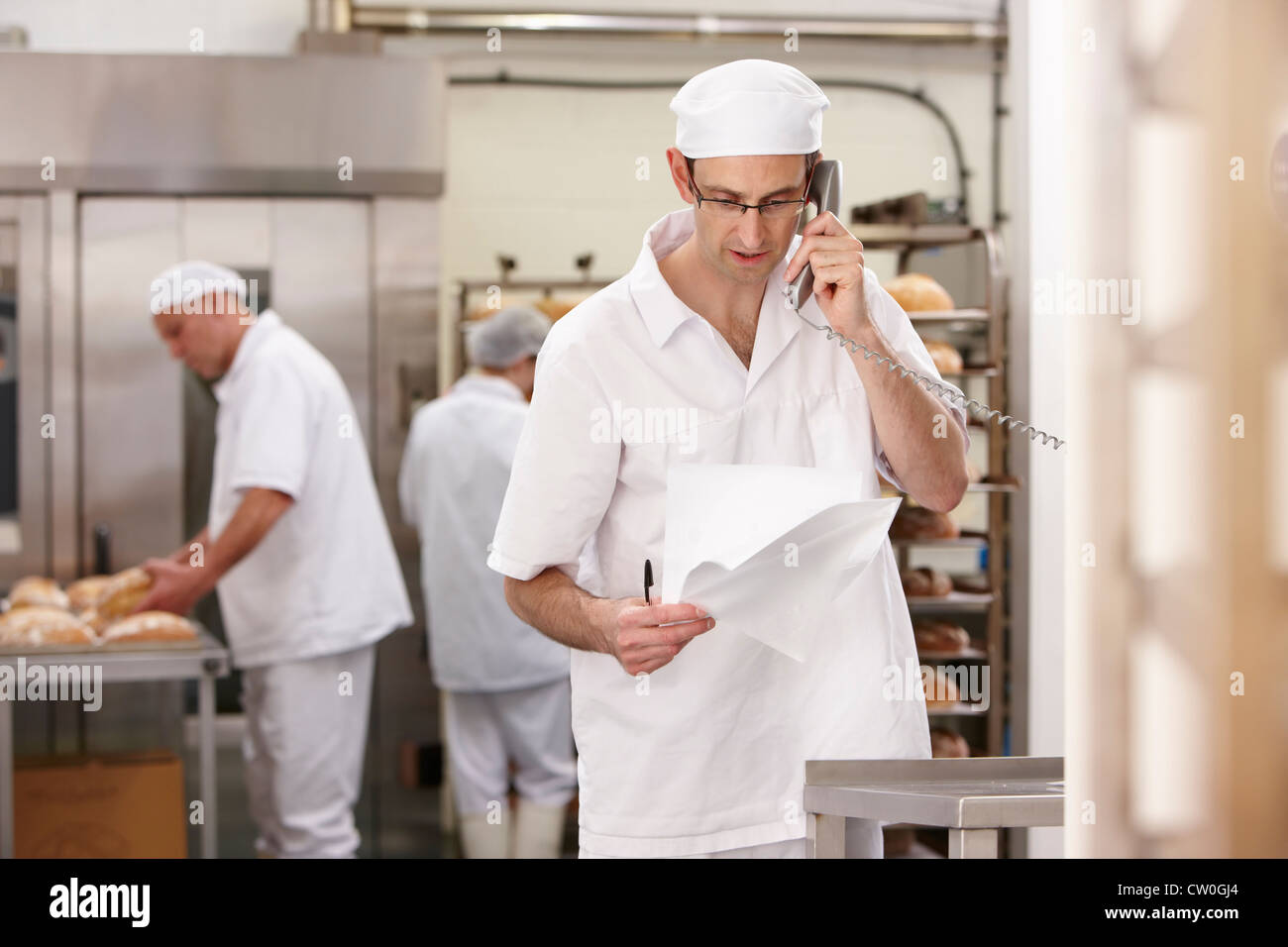Chef talking on phone in kitchen Stock Photo