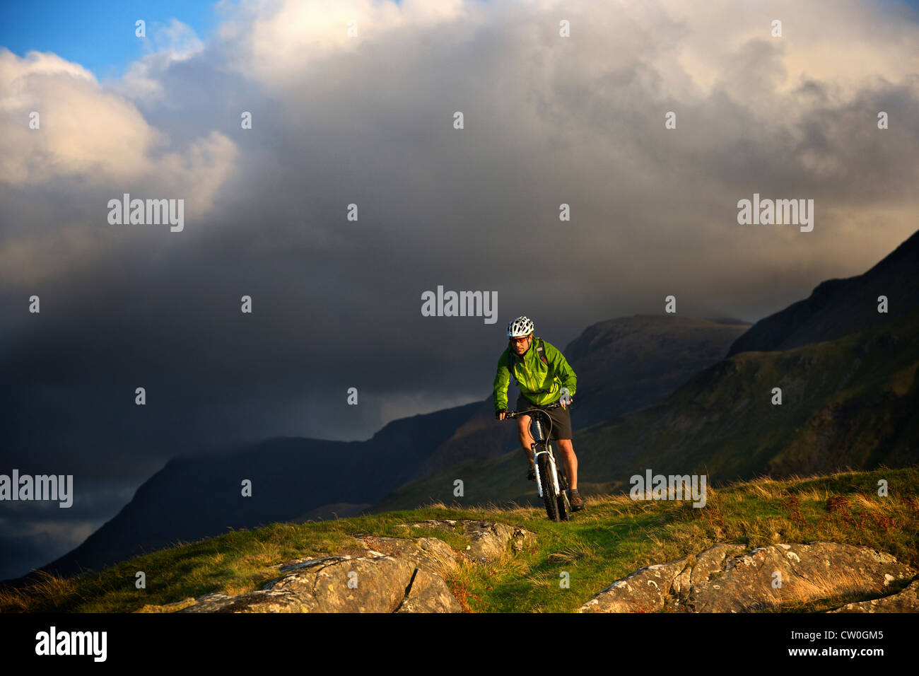 Mountain biker on grassy hillside Stock Photo