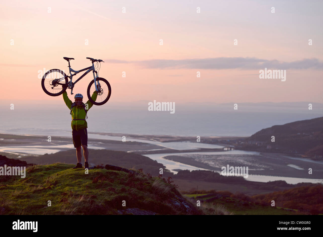 Man holding bicycle on hilltop Stock Photo