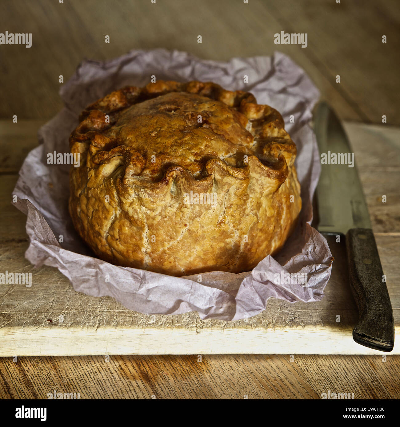 Baked pork pie on wooden board Stock Photo