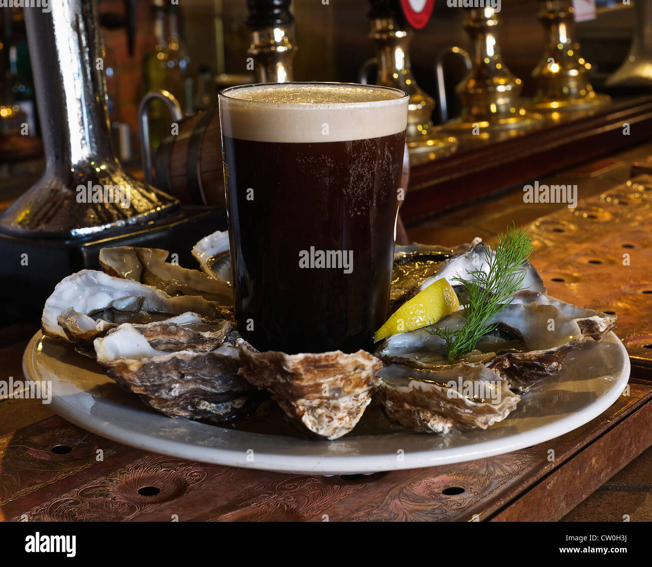 Plate of oysters and stout in bar Stock Photo