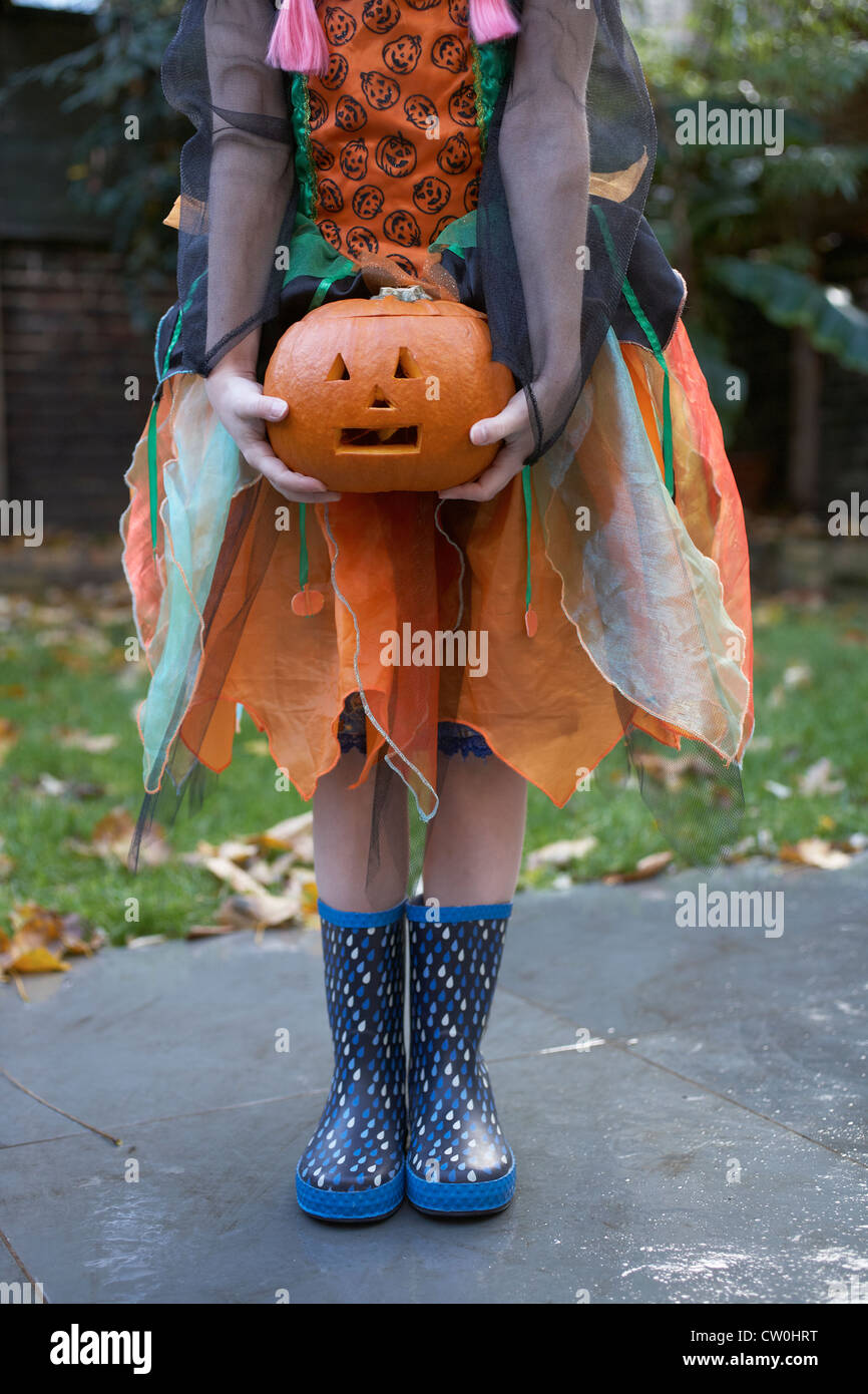 Girl in Halloween costume with pumpkin Stock Photo