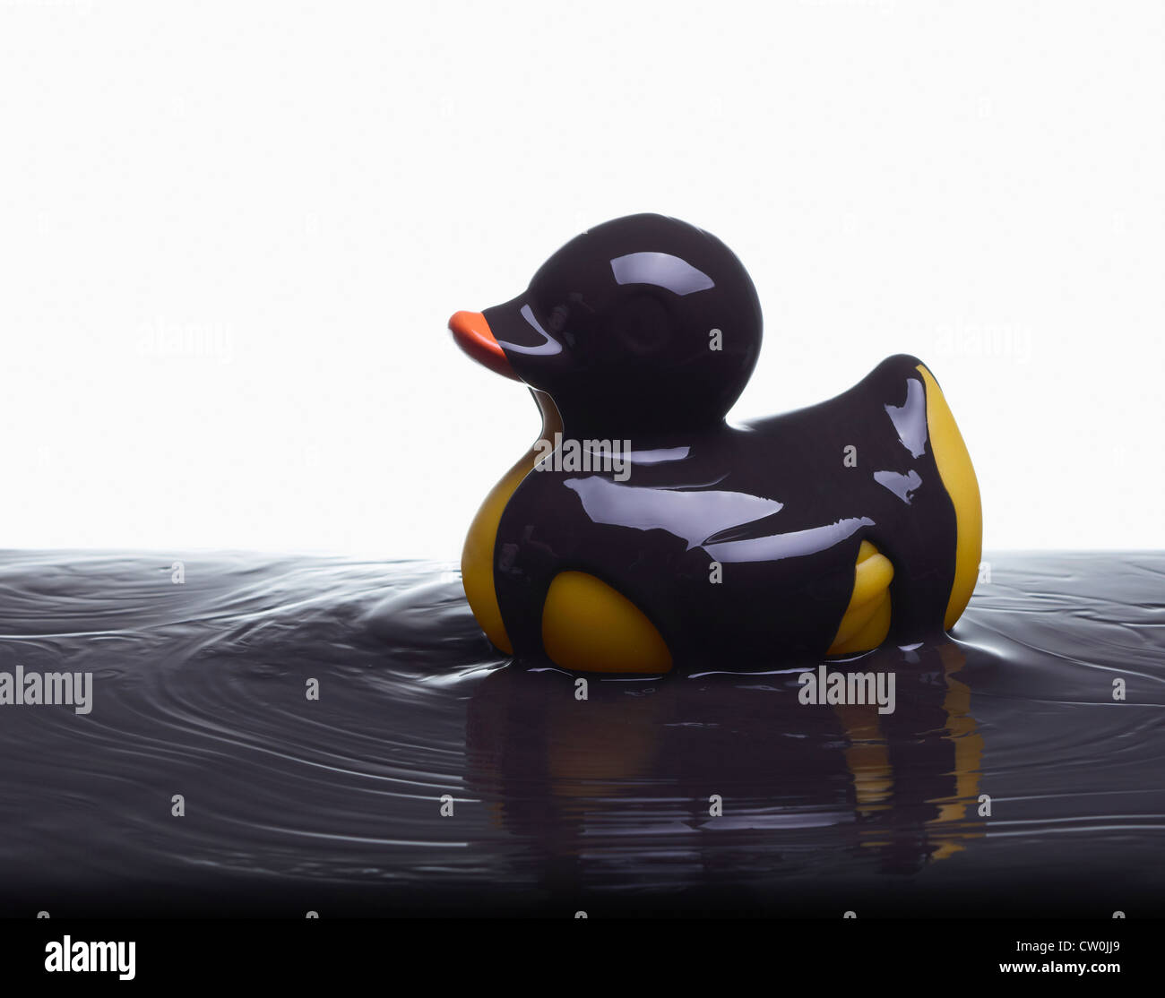 Rubber duck covered in oil Stock Photo