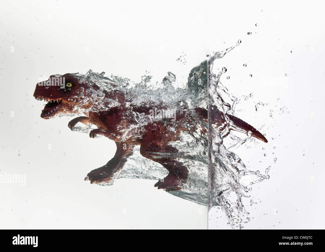 Toy dinosaur plunging into water Stock Photo