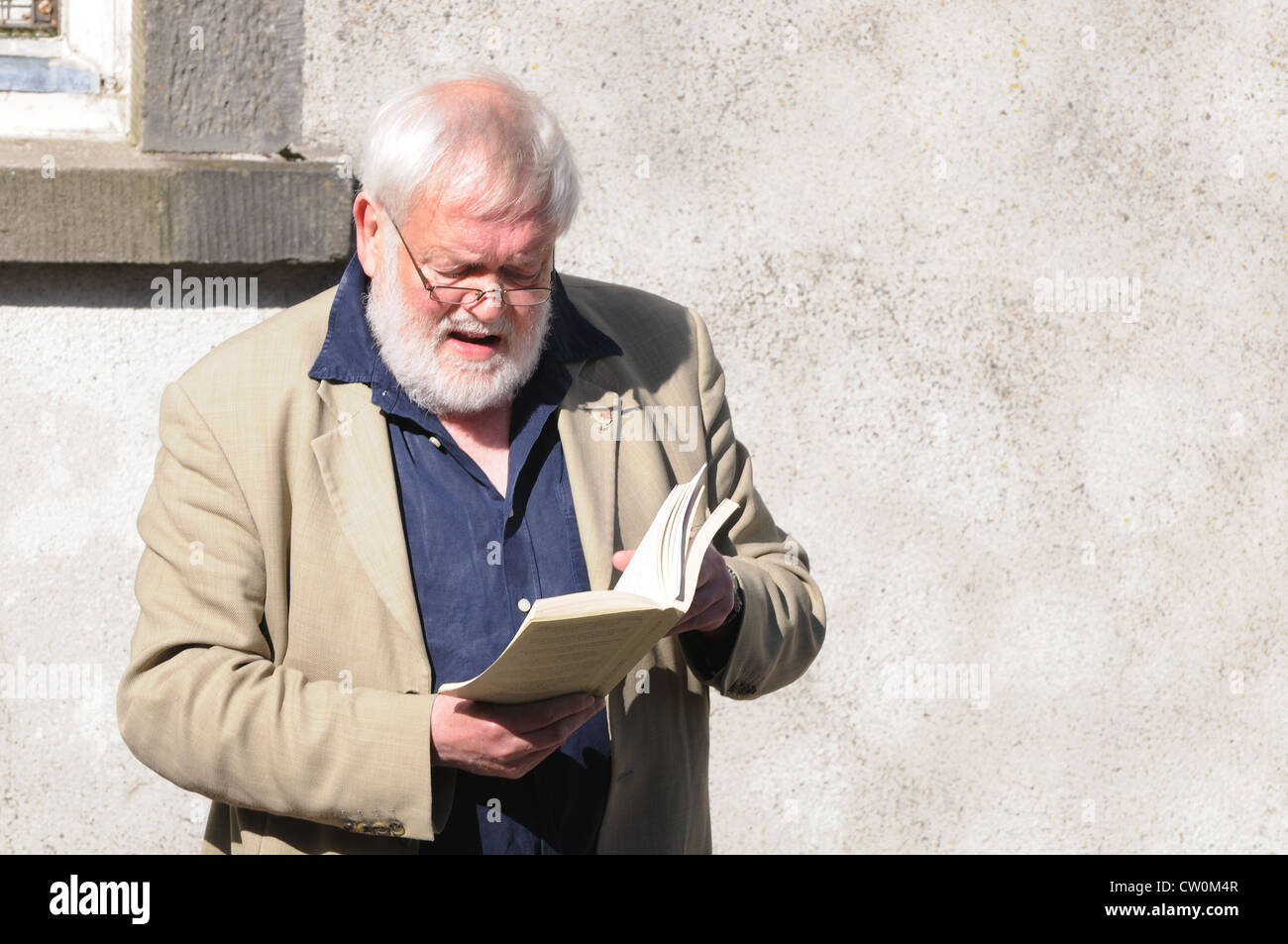 Michael Longley, CBE, reading one of his poems at the 3rd Feis Teamhra at the Hill of Tara, Ireland Stock Photo