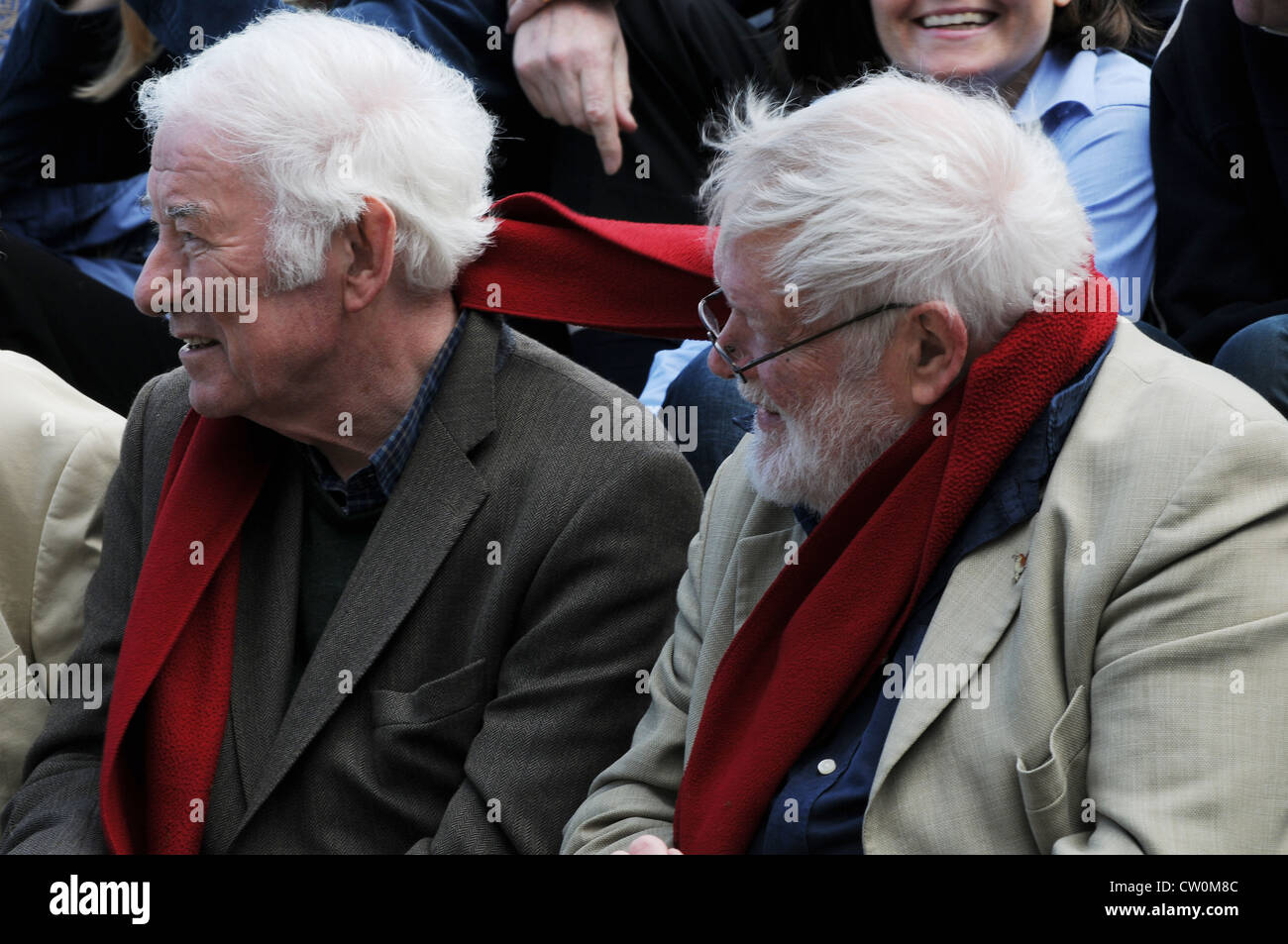 The ties that bind, Seamus Heaney & Michael Longley share a red scarf while listening to a reading on the Hill of Tara, Ireland Stock Photo