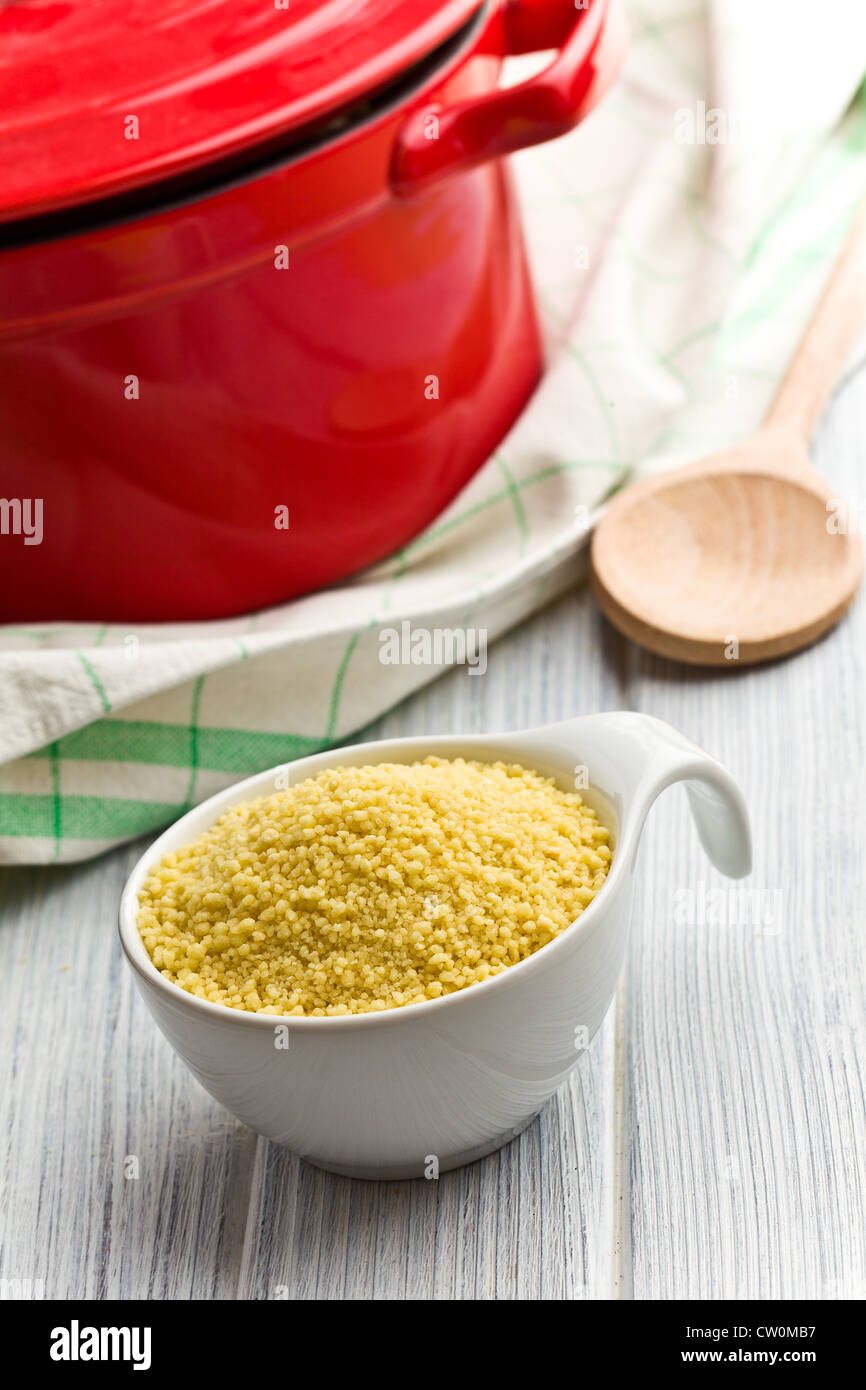 couscous in bowl on wooden table Stock Photo