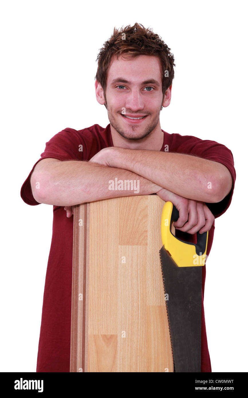 Handsome young man with a floorboard and saw Stock Photo Alamy