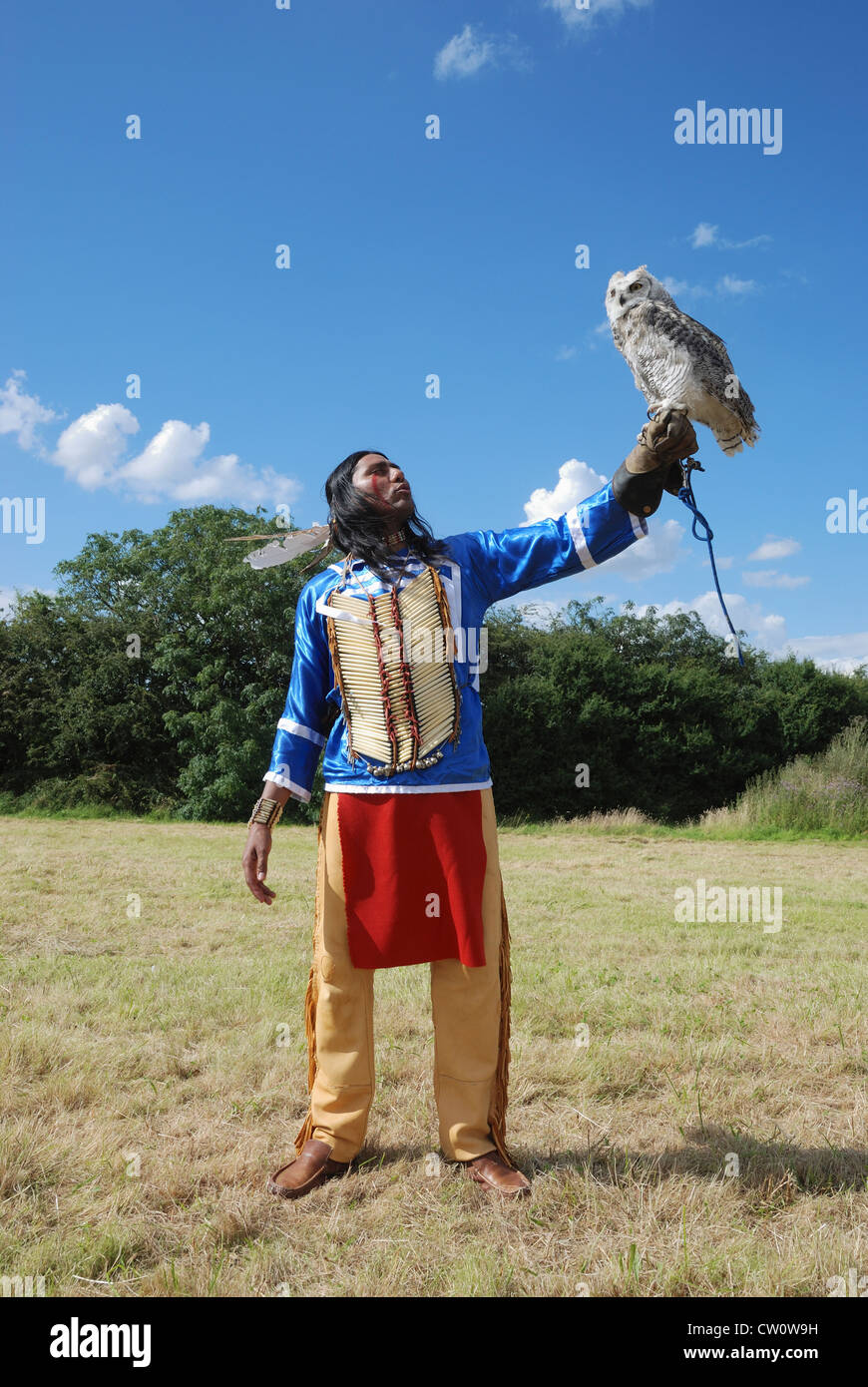 A man posing in traditional Lakota (Sioux) dress with a Great Horned