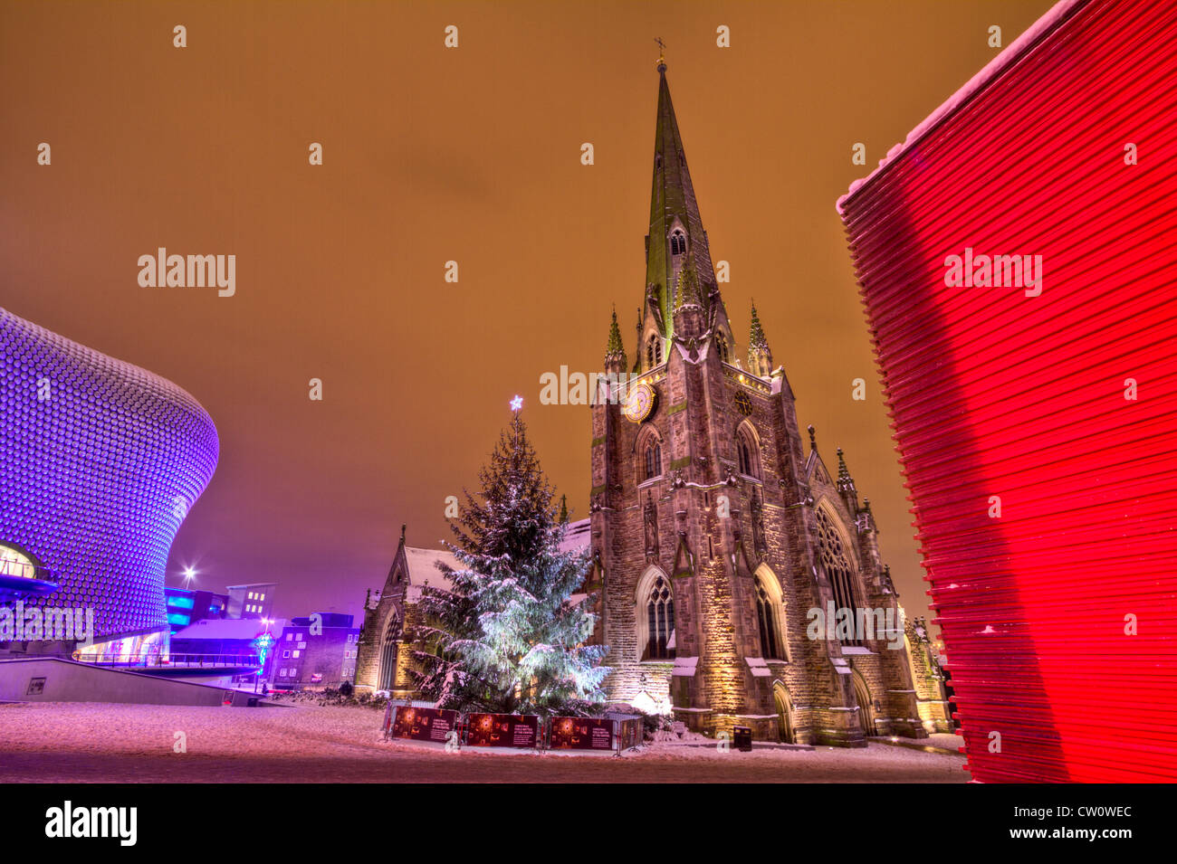 A snow covered Birmingham Cathedral flanked by the blue Bullring and