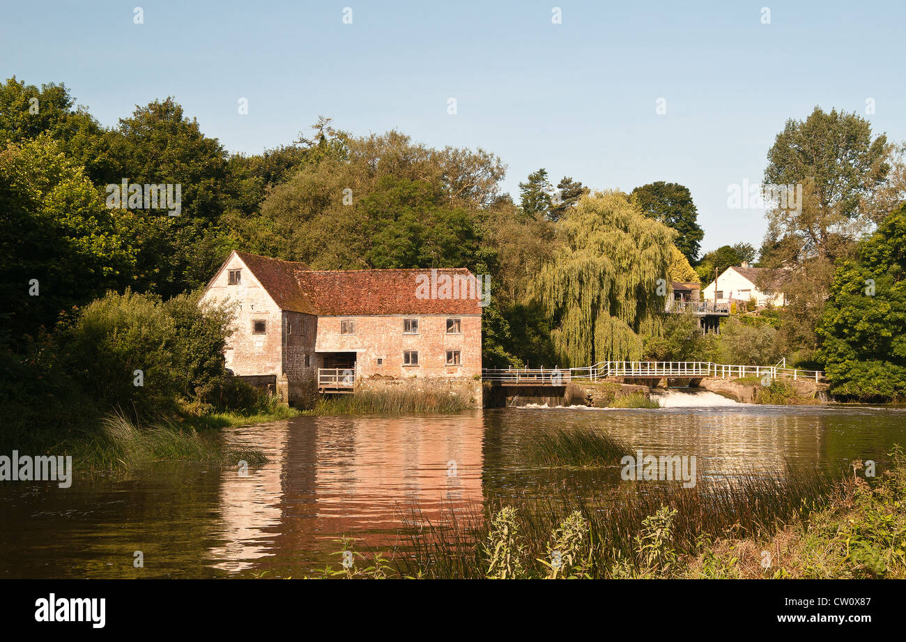 Silt-laden water rushing over a weir on the River Stour Blandford Dorset  England UK Stock Photo - Alamy