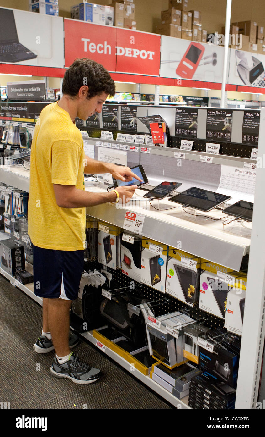 Eighteen year old college freshman shops for tablet computer and software at office supply store in Texas. Stock Photo
