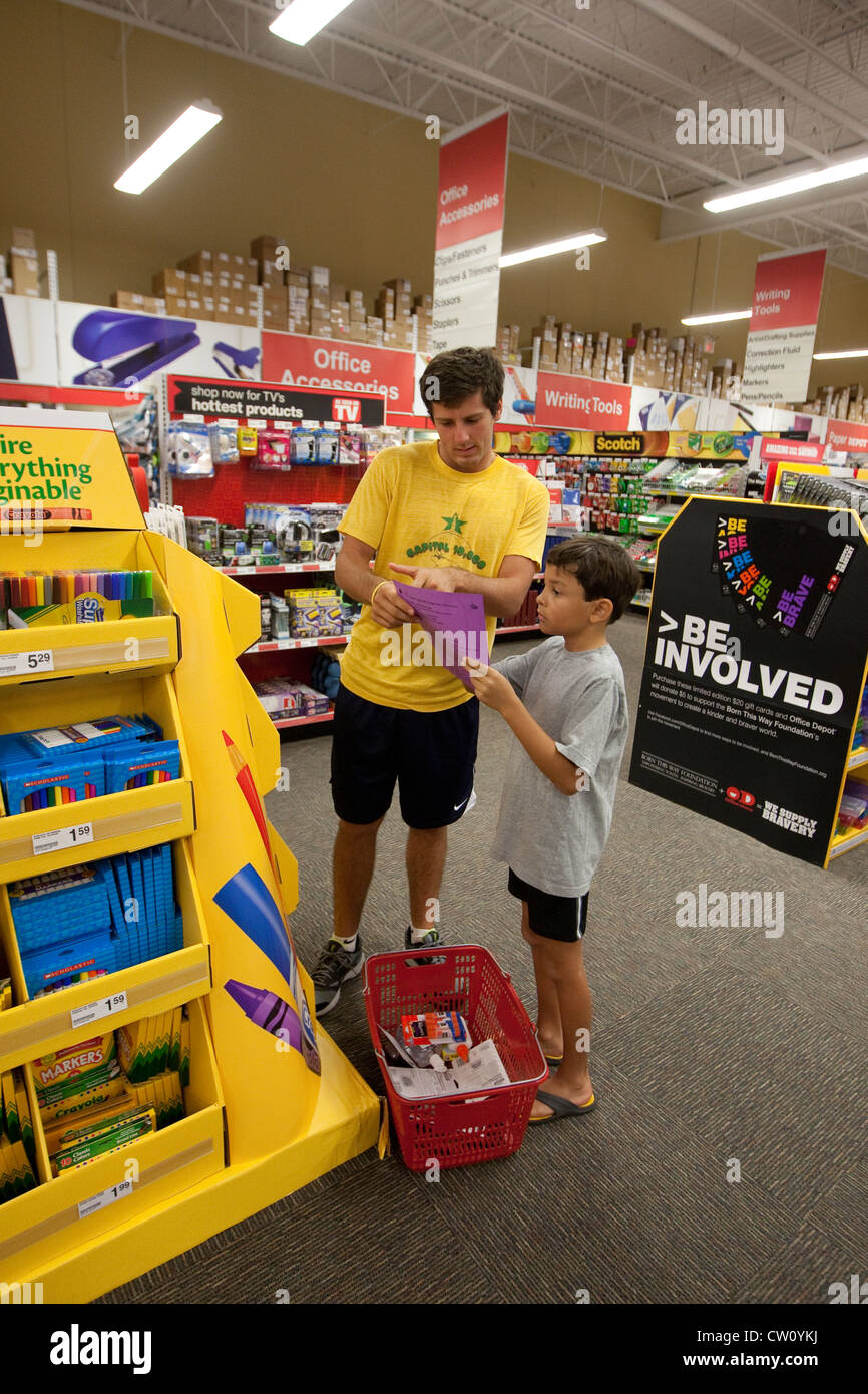 Eighteen year old college freshman, takes 8 year old brother shopping for school supplies at an office supply store in Texas Stock Photo