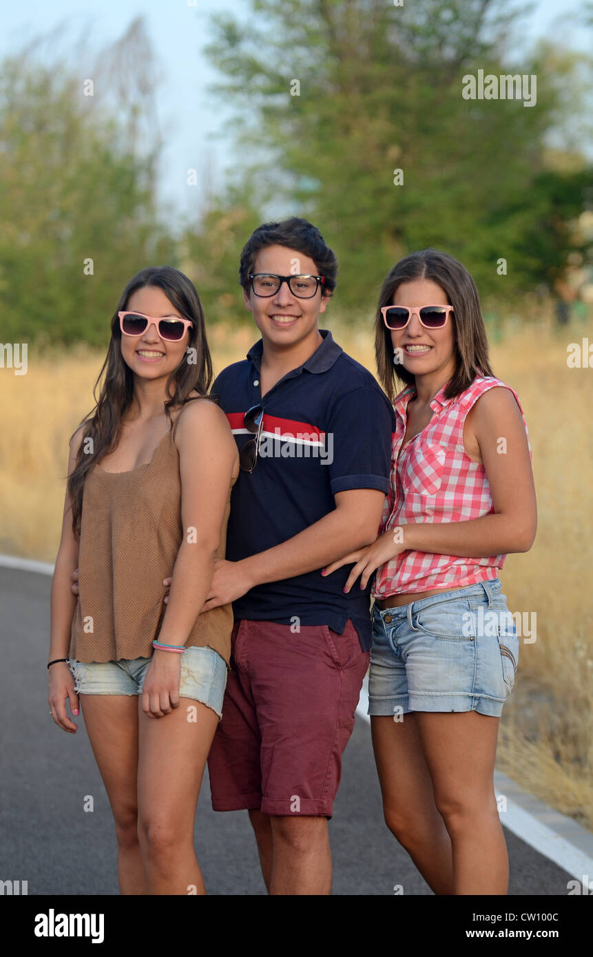 Two young women and a man posing outdoors Stock Photo - Alamy
