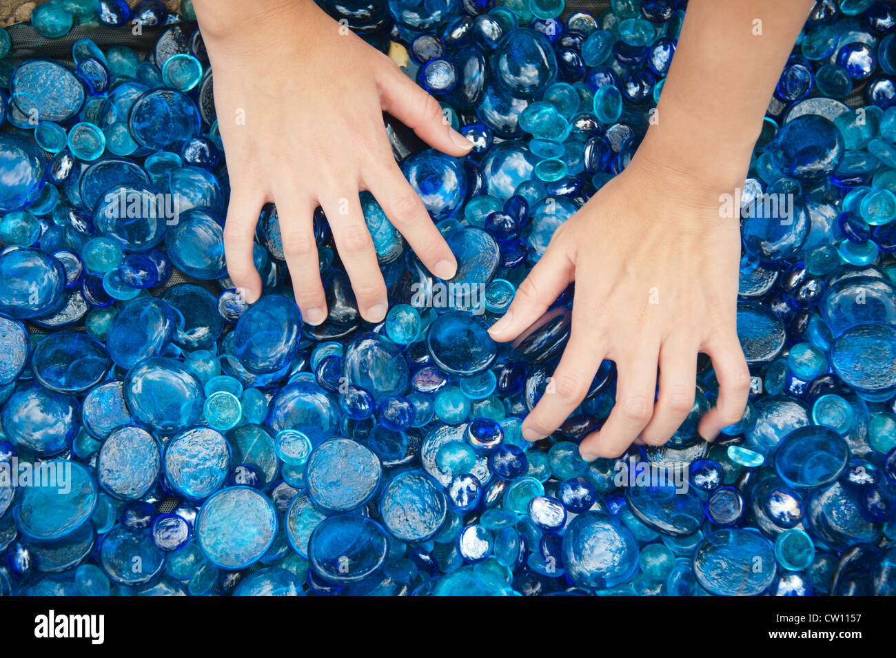 Hands sifting through sea glass Stock Photo