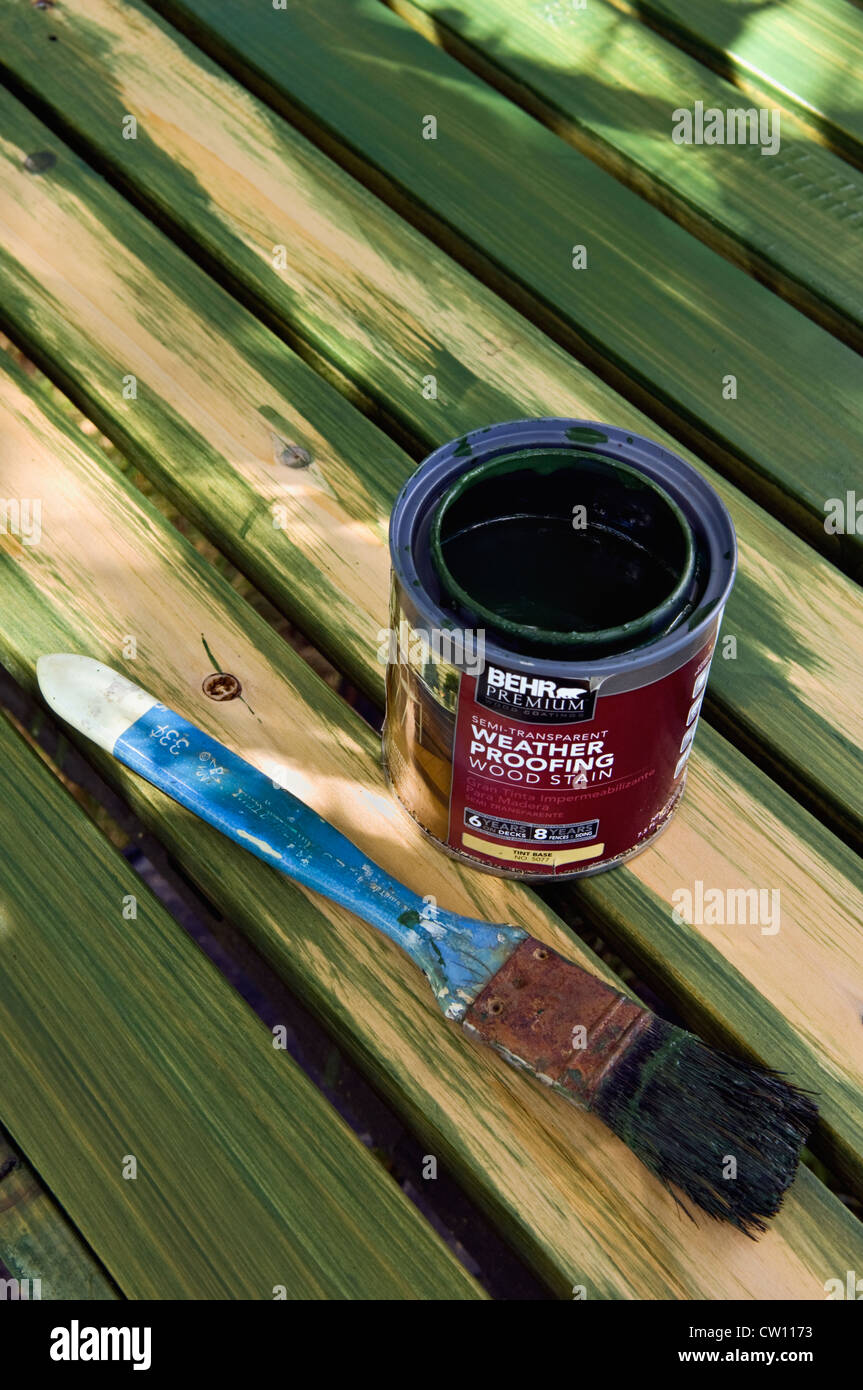 Open Can of Wood Stain and Wet Paint Brush on Partially Stained Wood