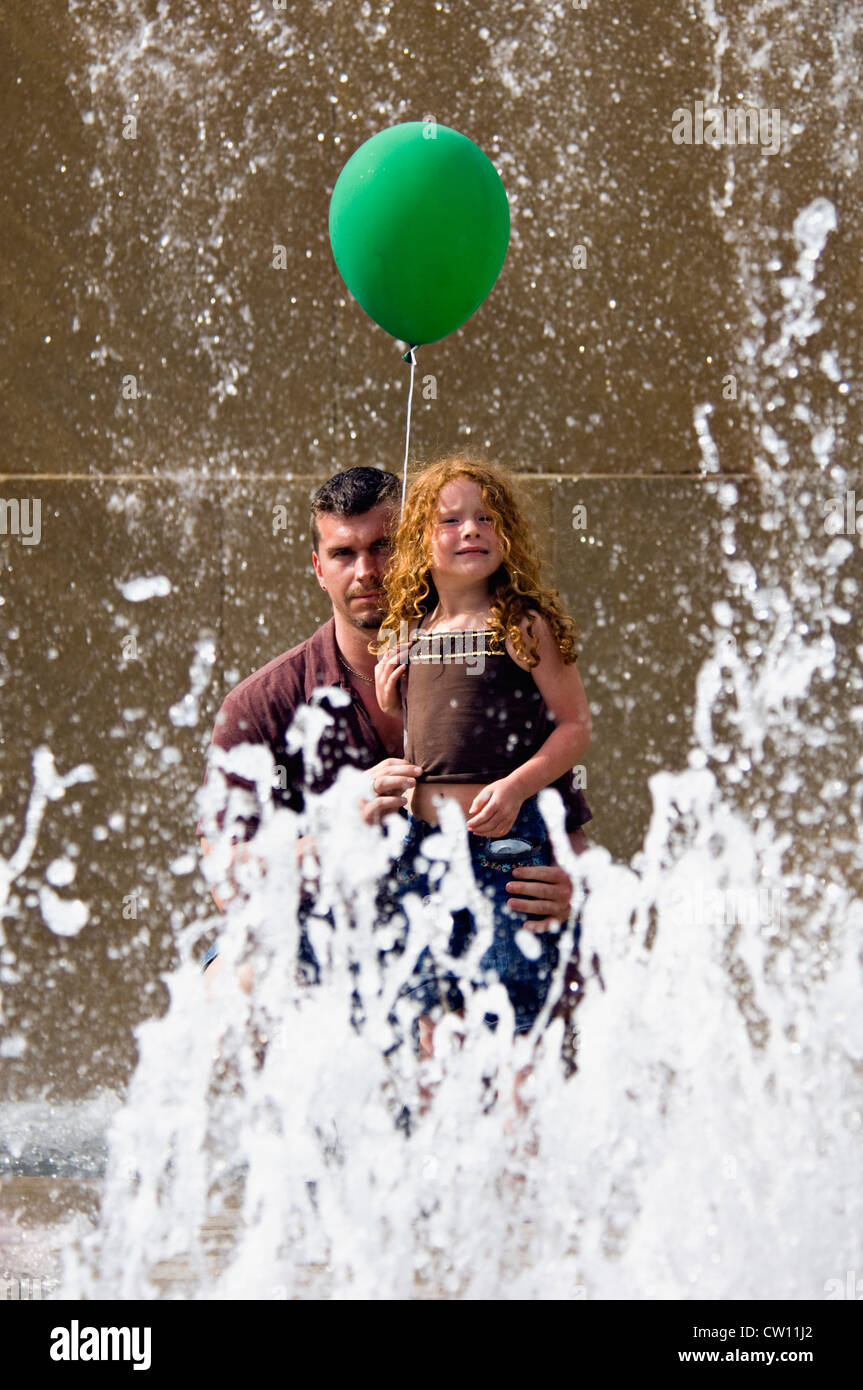 Father and Young Daughter with Balloon seen through Fountain in Louisville, Kentucky Stock Photo