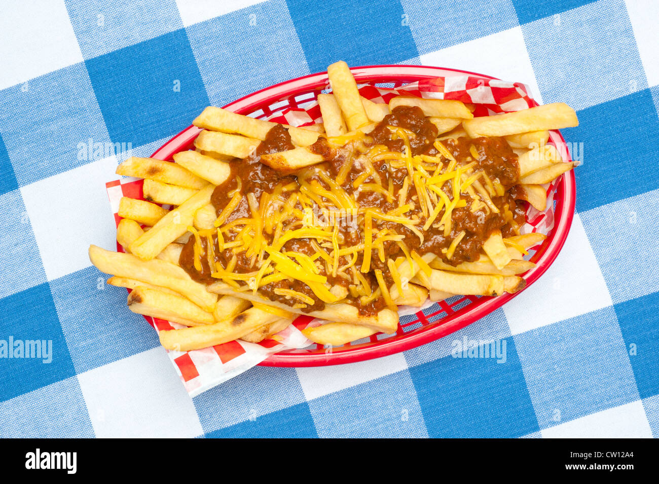 A basket of chili cheese fries covered in hot chili and melted cheddar cheese. Stock Photo