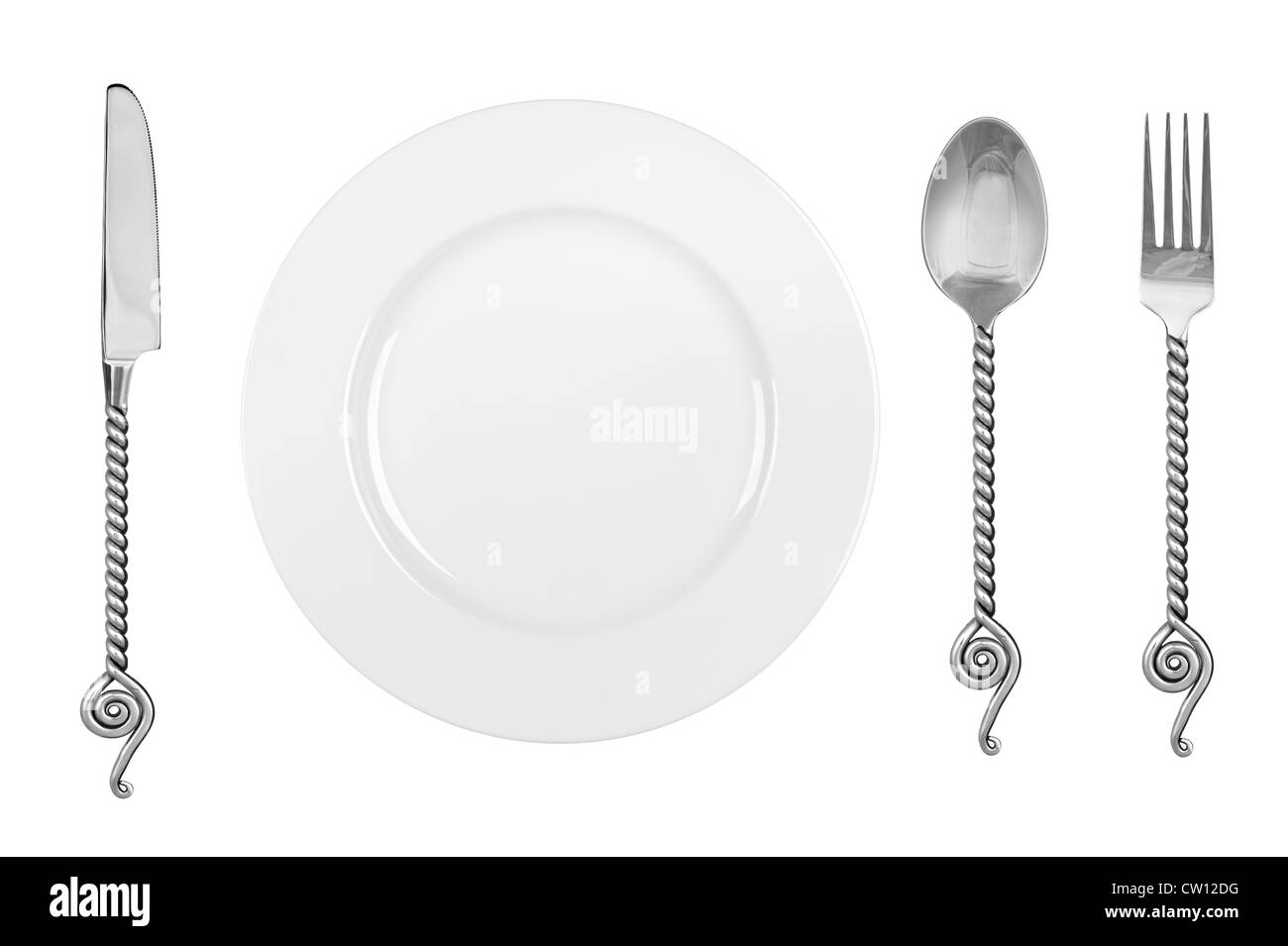 A table setting with a dinner plate, and fancy silverware consisting of a fork, knife and spoon. Stock Photo
