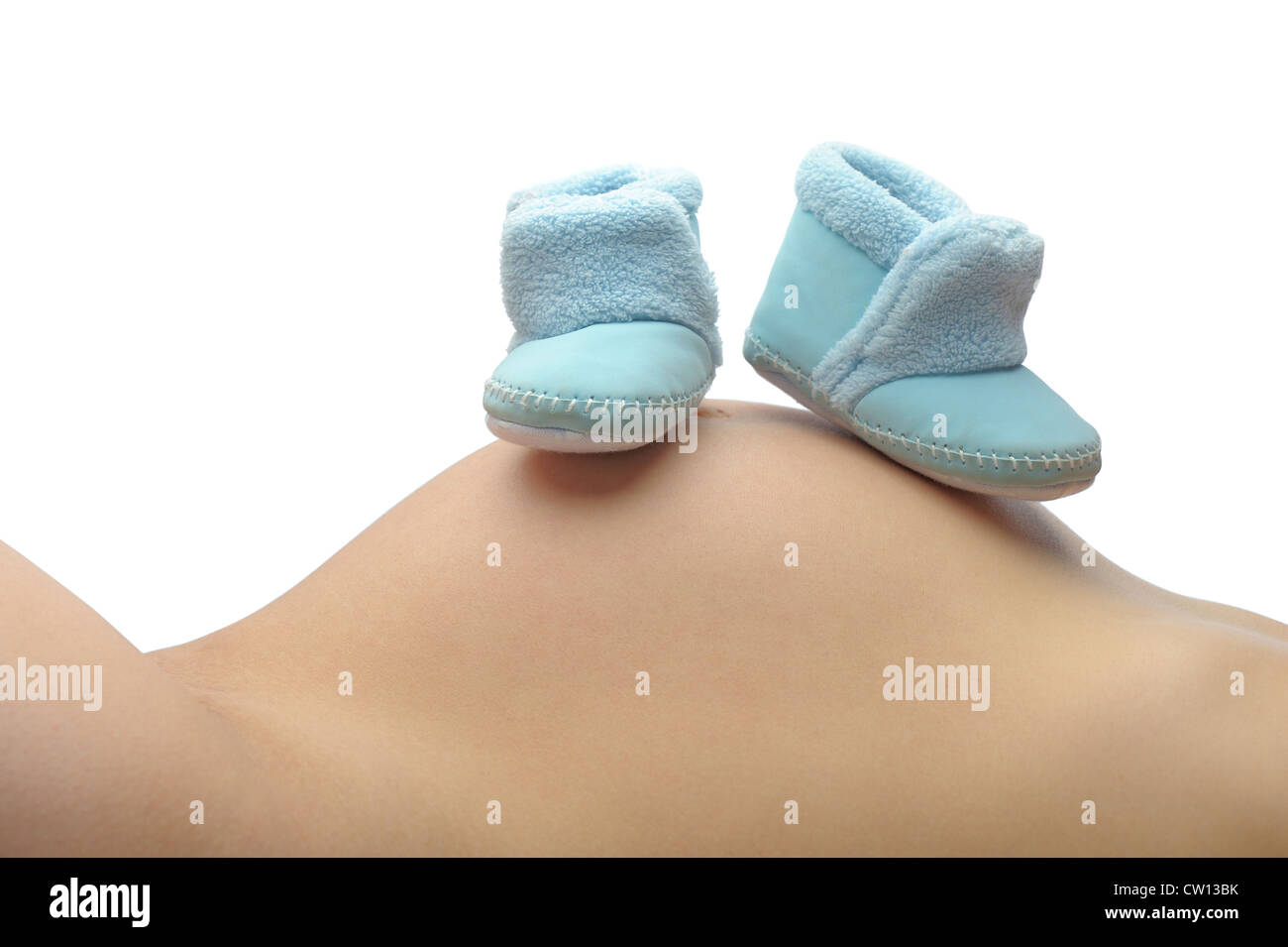 A mother lays back and rests her unborn childs shoes on her belly Stock Photo