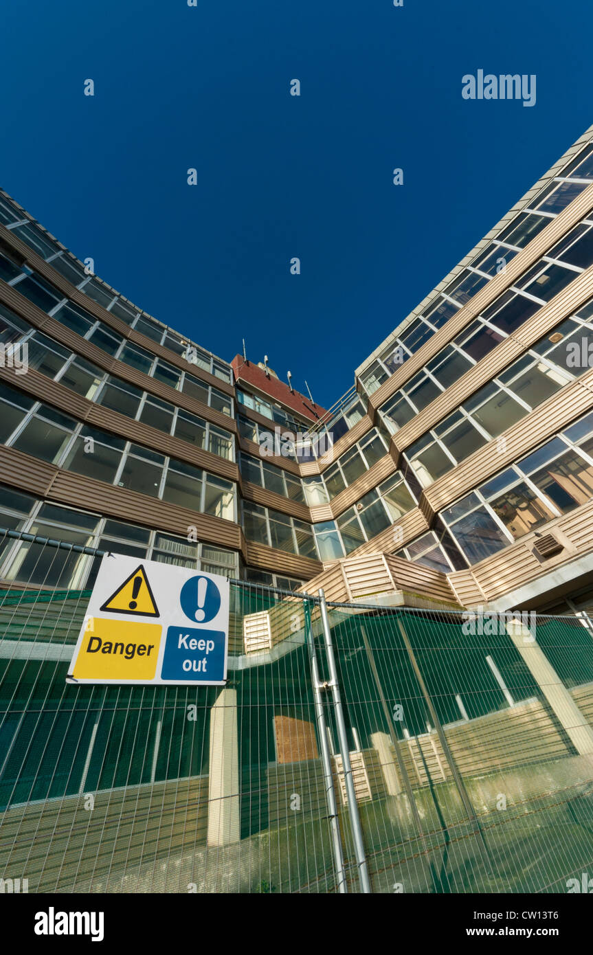 Danger keep out sign in front of closed office block HMSO Stock Photo