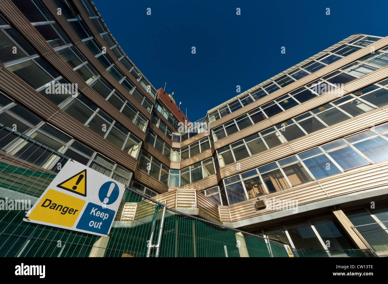 Danger keep out sign in front of closed office block HMSO Stock Photo