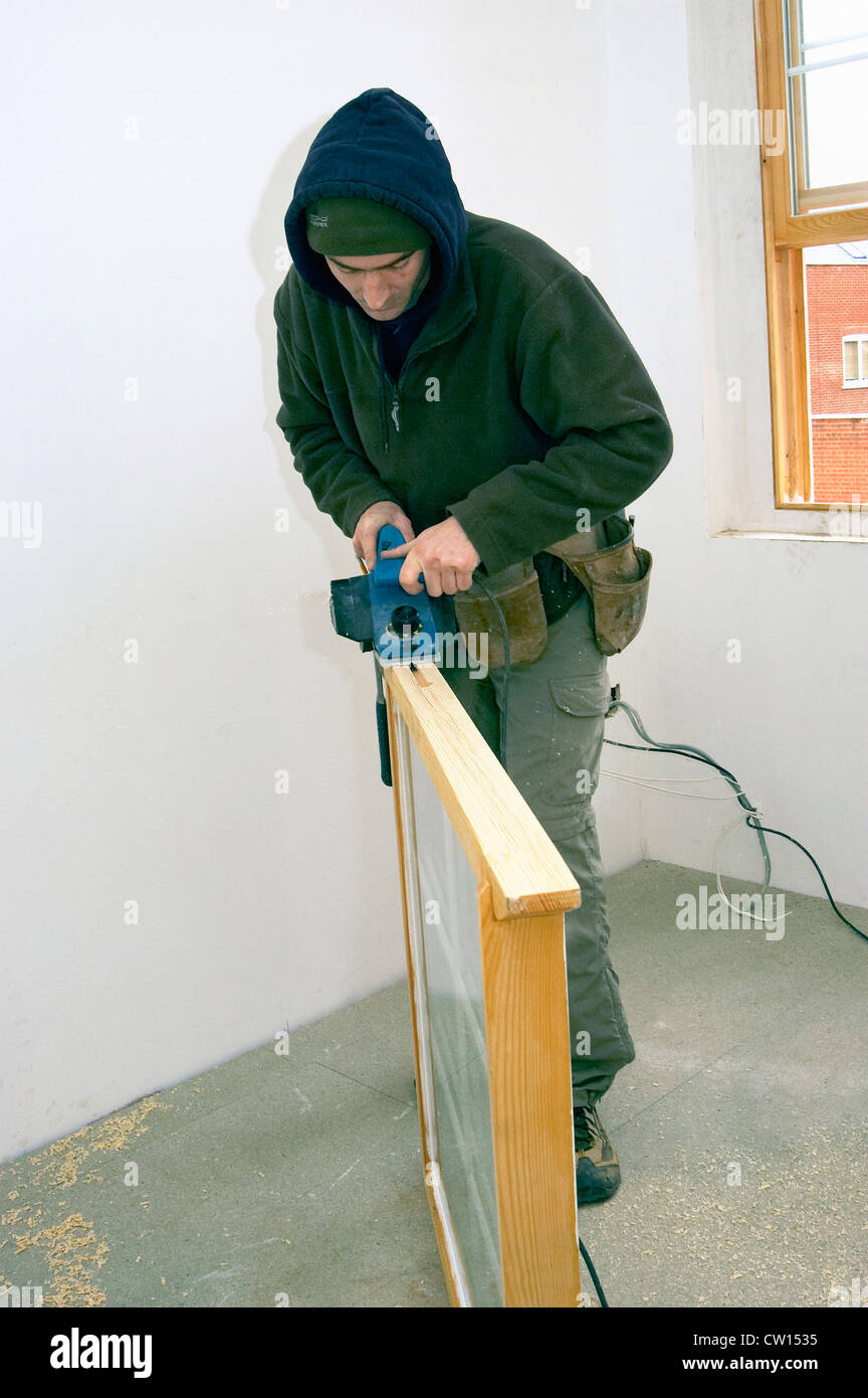 Handyman sanding new sash window Stock Photo Alamy