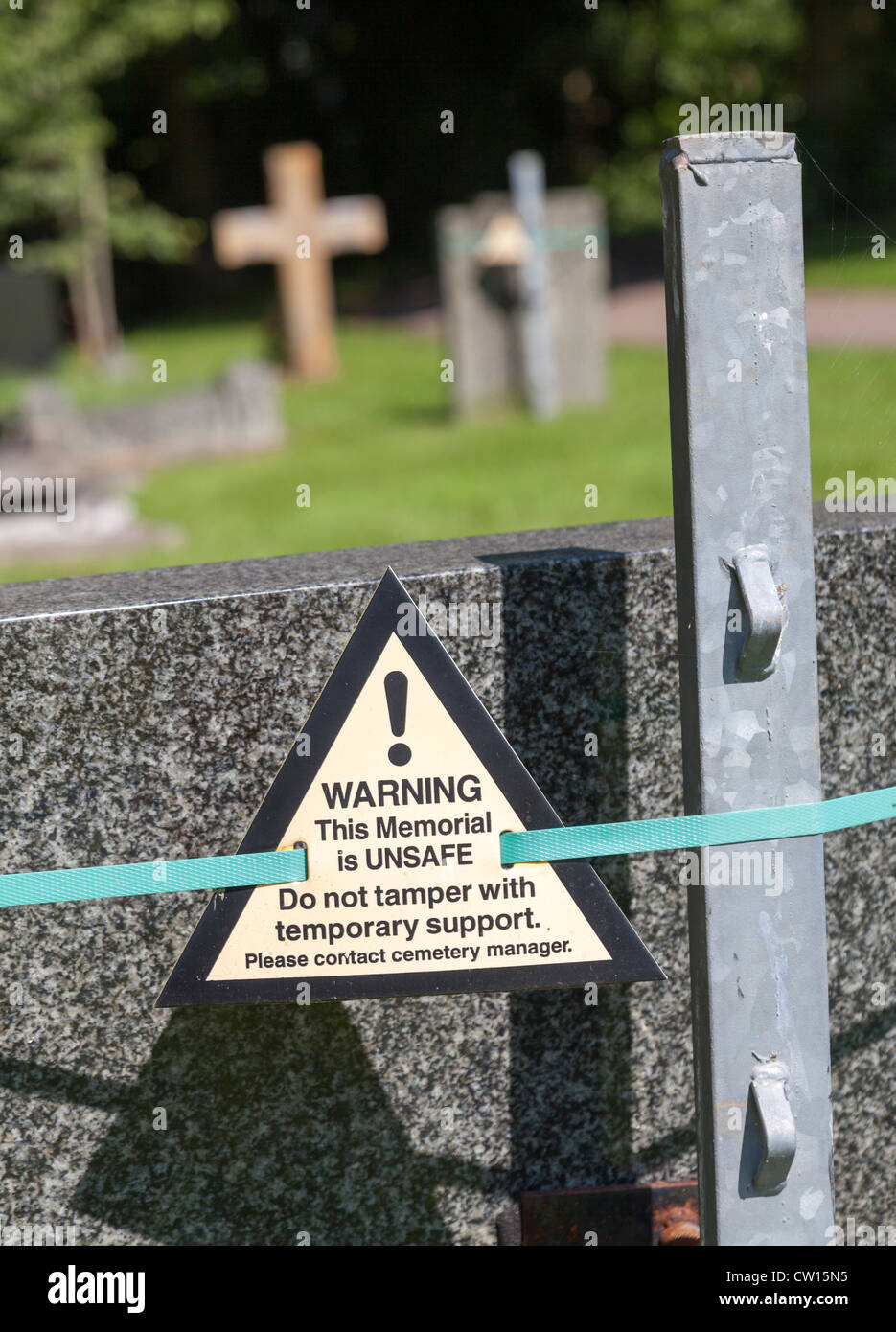 Warning sign on support for gravestone, Llanfoist cemetery, Abergavenny, Wales, UK Stock Photo
