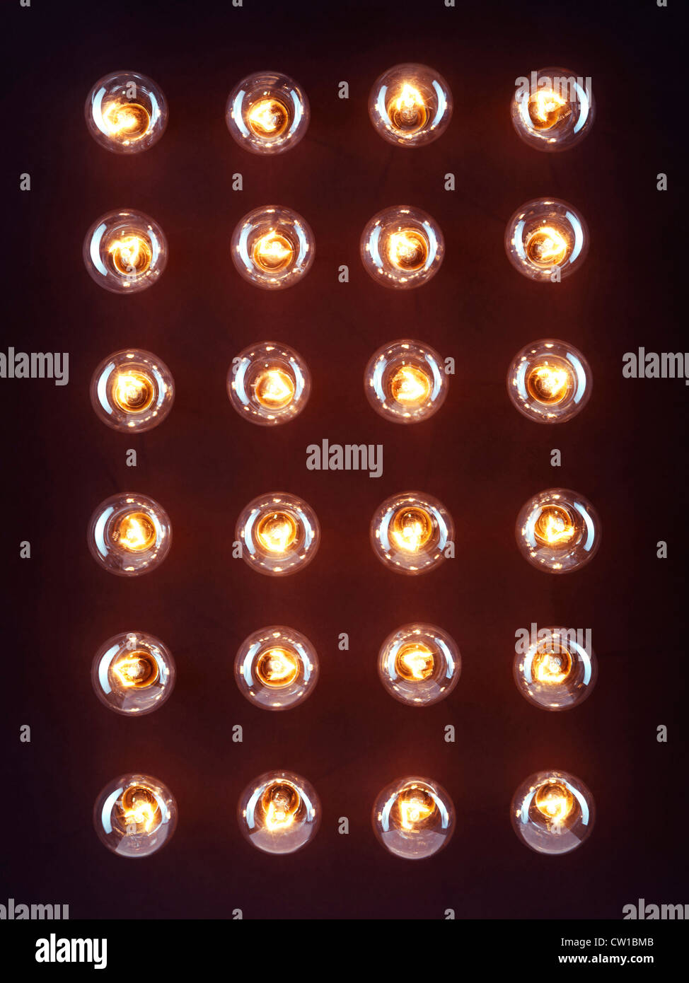 A group of illuminated incandescent light bulbs shining isolated on black background Stock Photo