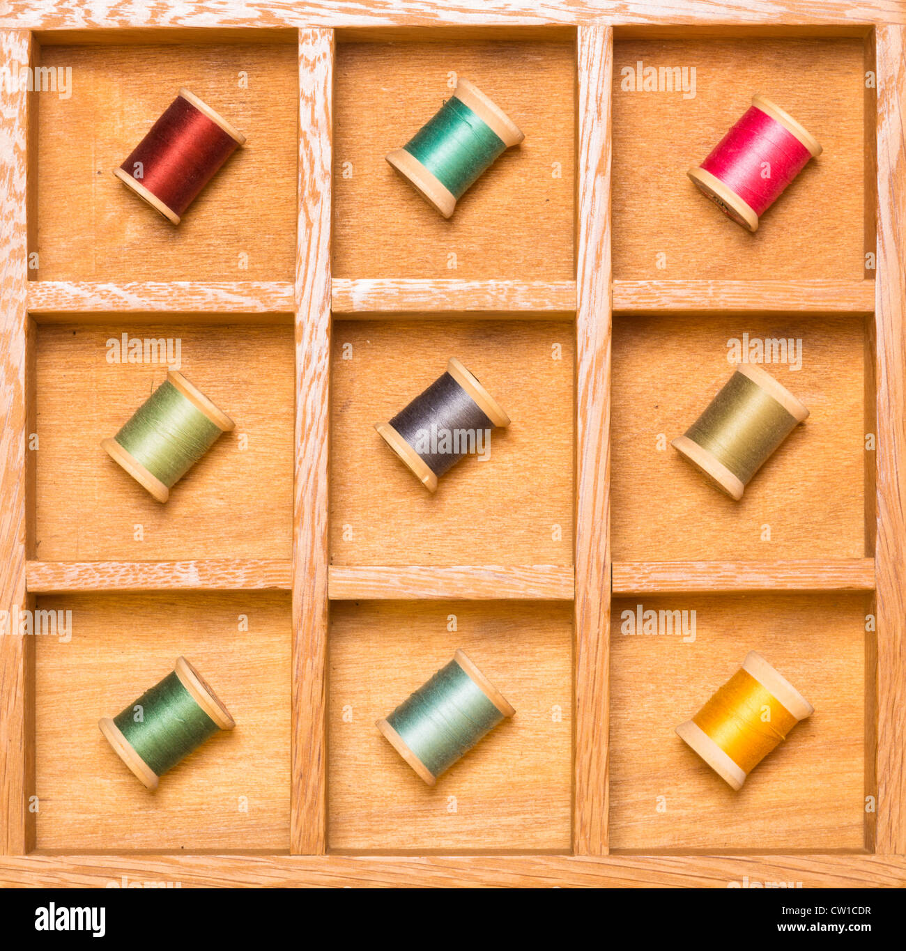 Thread on spools in wooden shadow box Stock Photo - Alamy