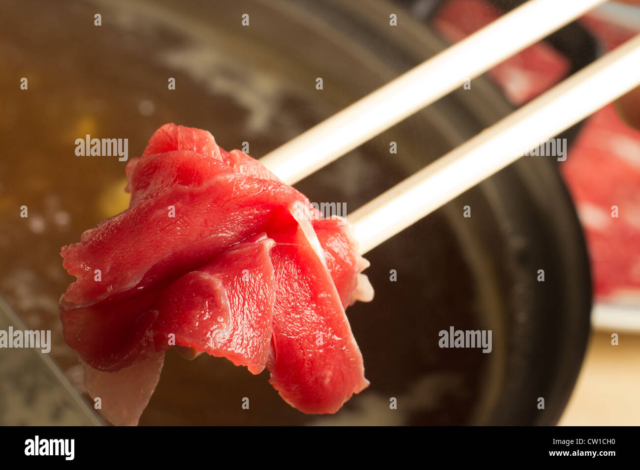 Dipping lamb into a Chinese broth hotpot Stock Photo